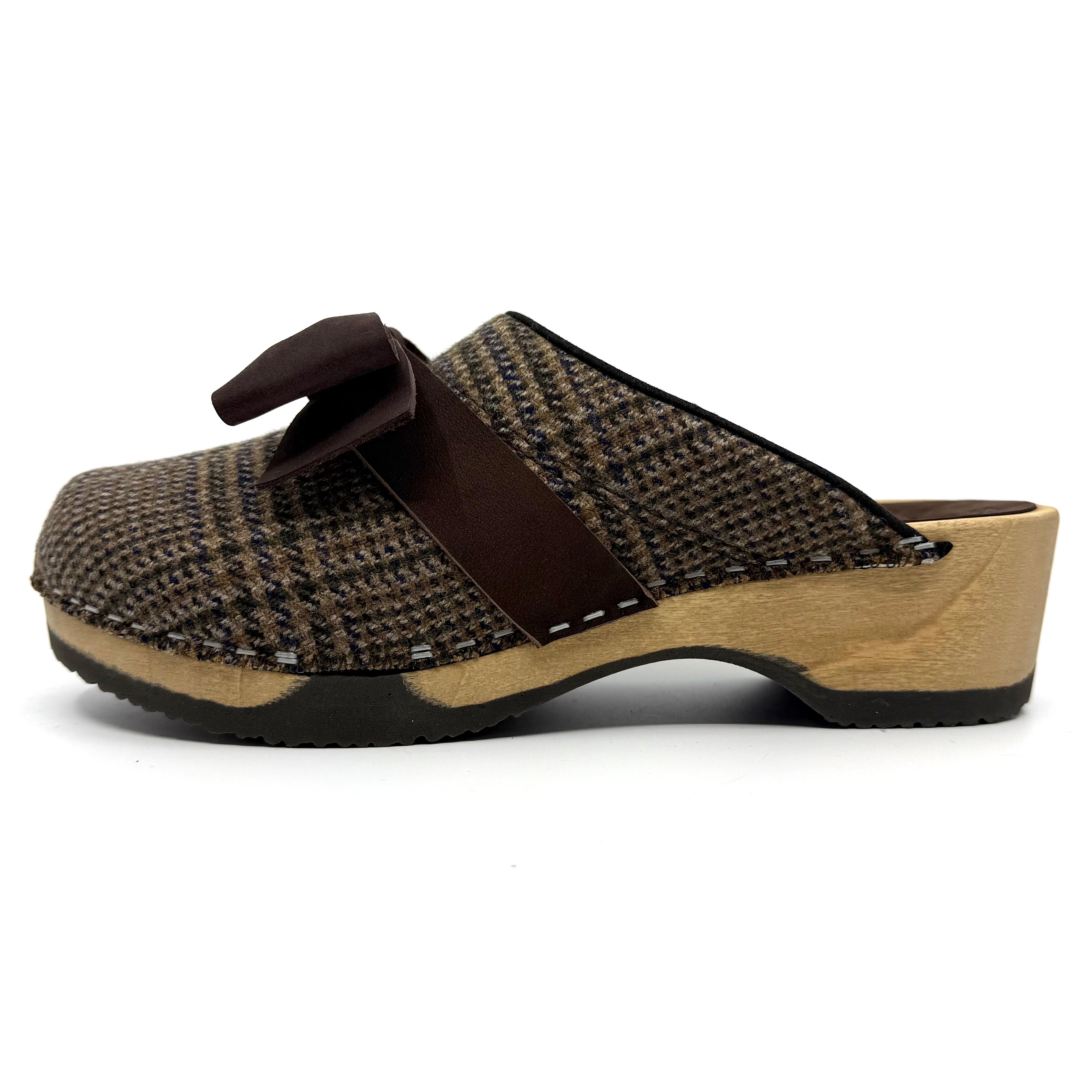 Brown and beige clog shoe with a strap on a white background