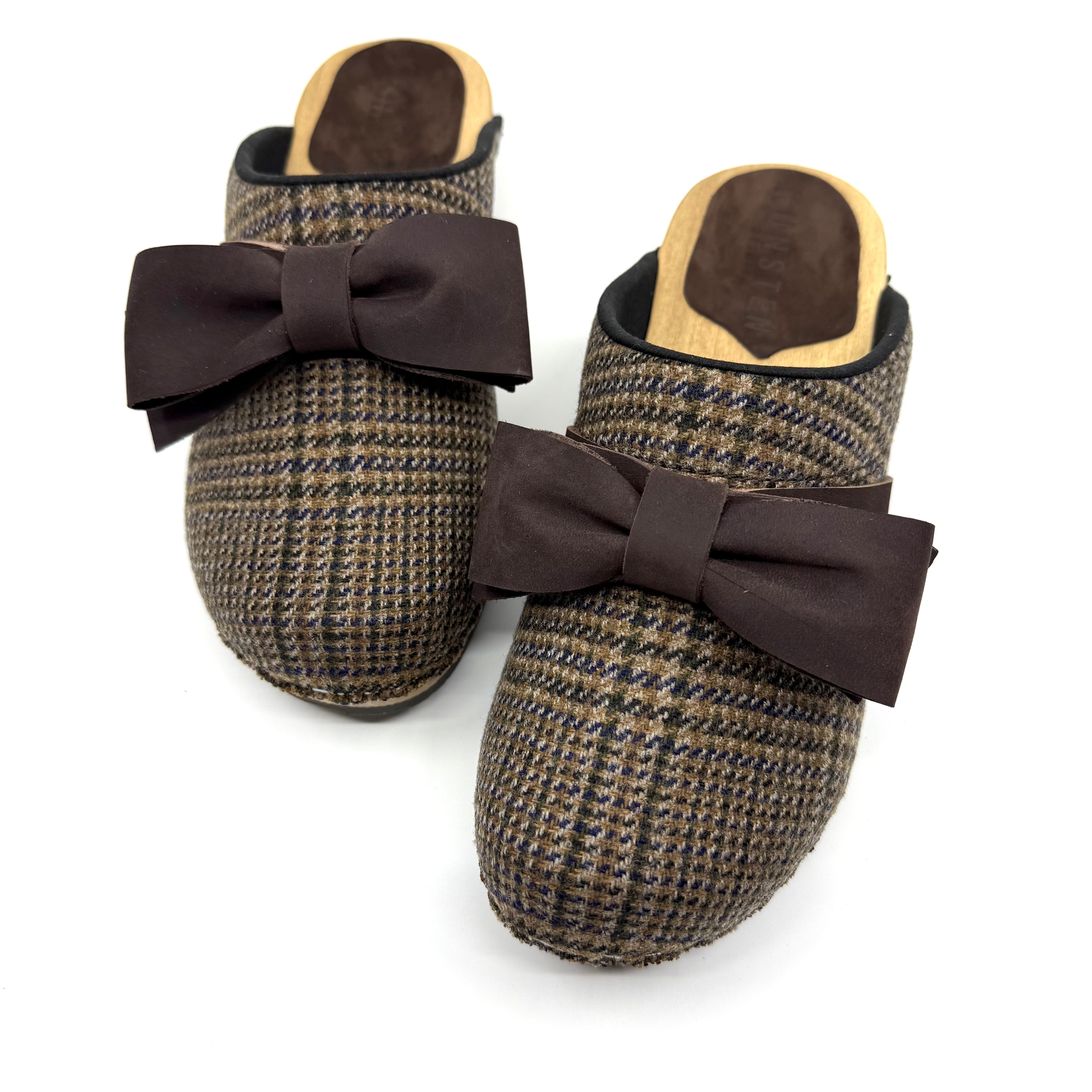 Pair of brown houndstooth slippers with large bows on a white background