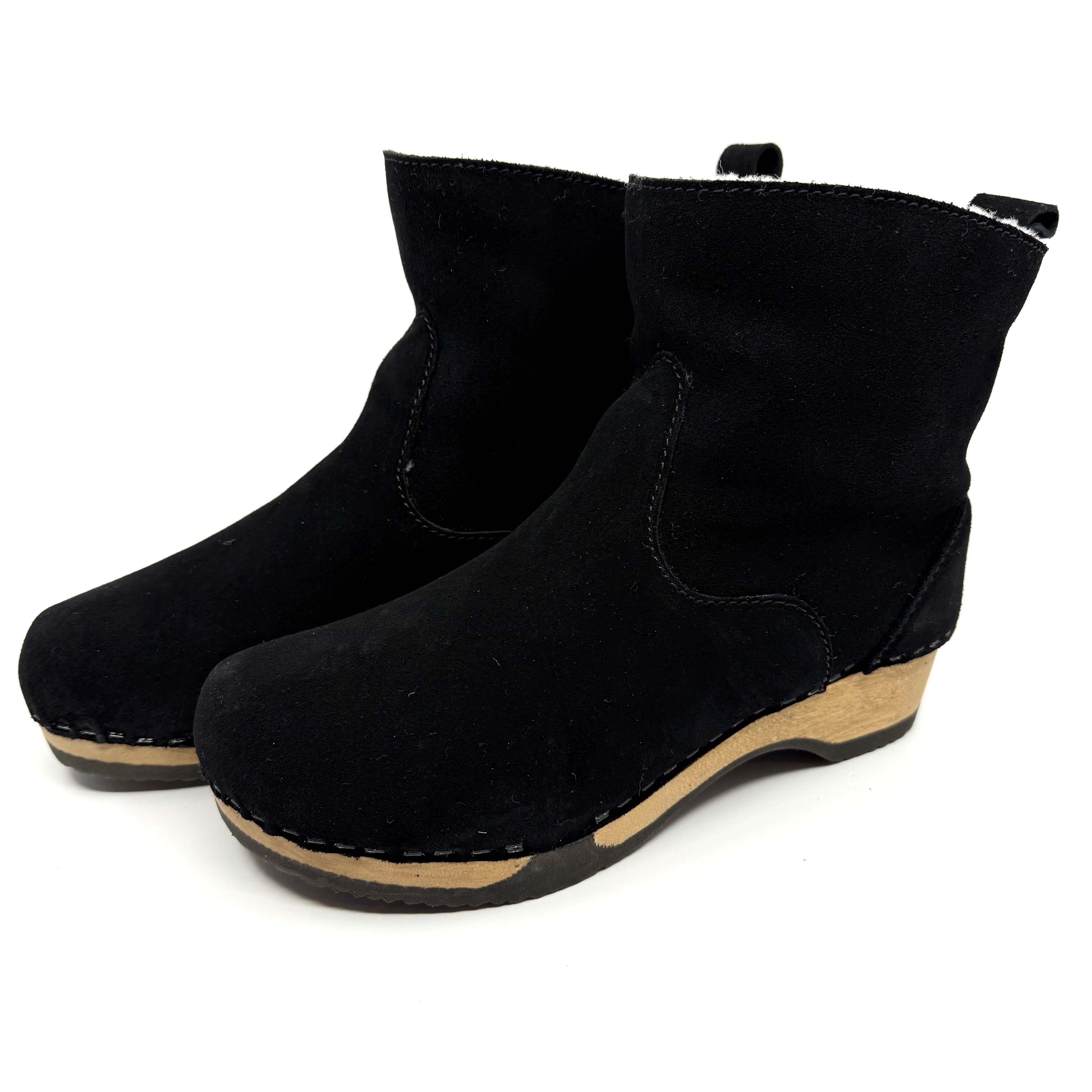 Black wedge ankle boots on a white background