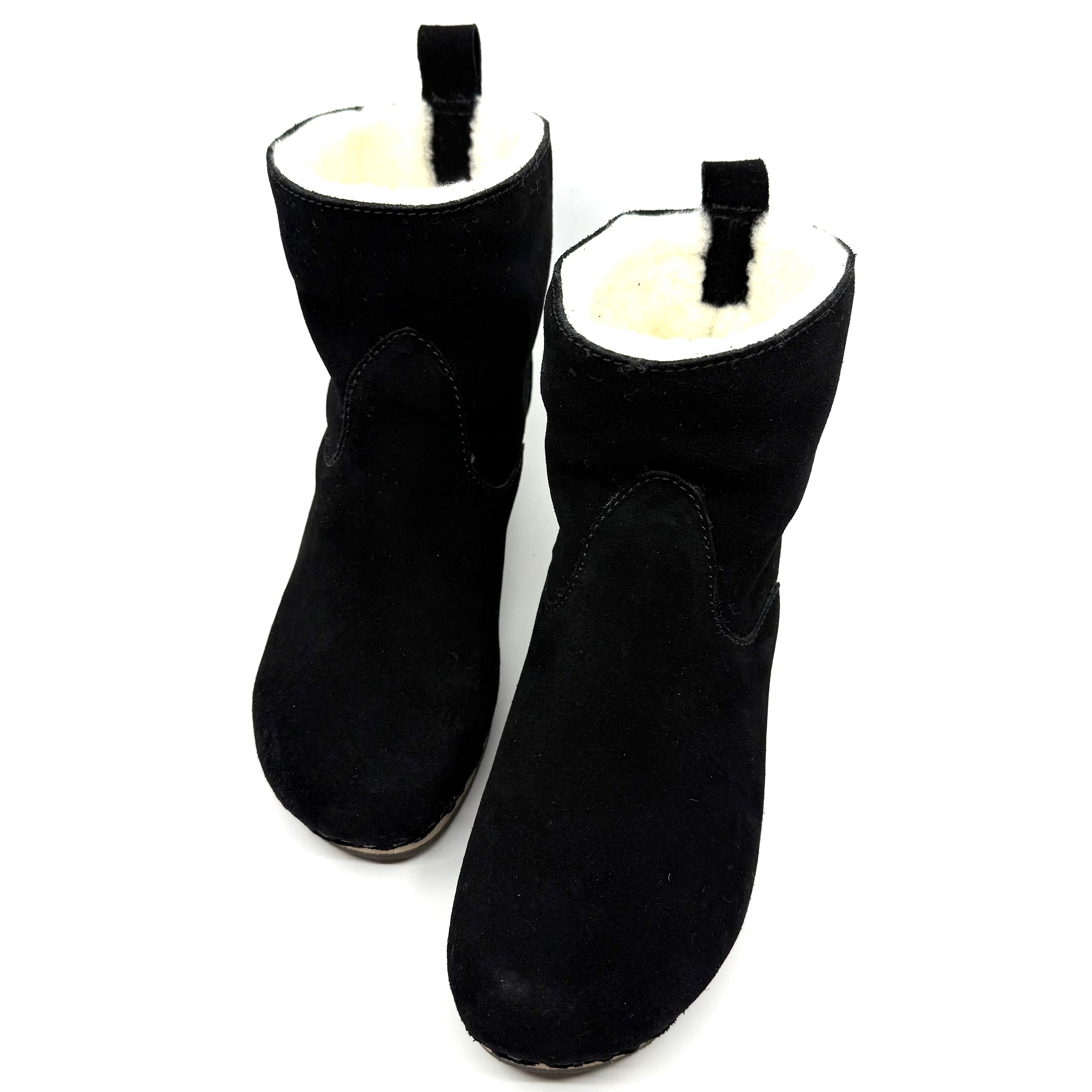 Pair of black ankle boots with white lining on a white background