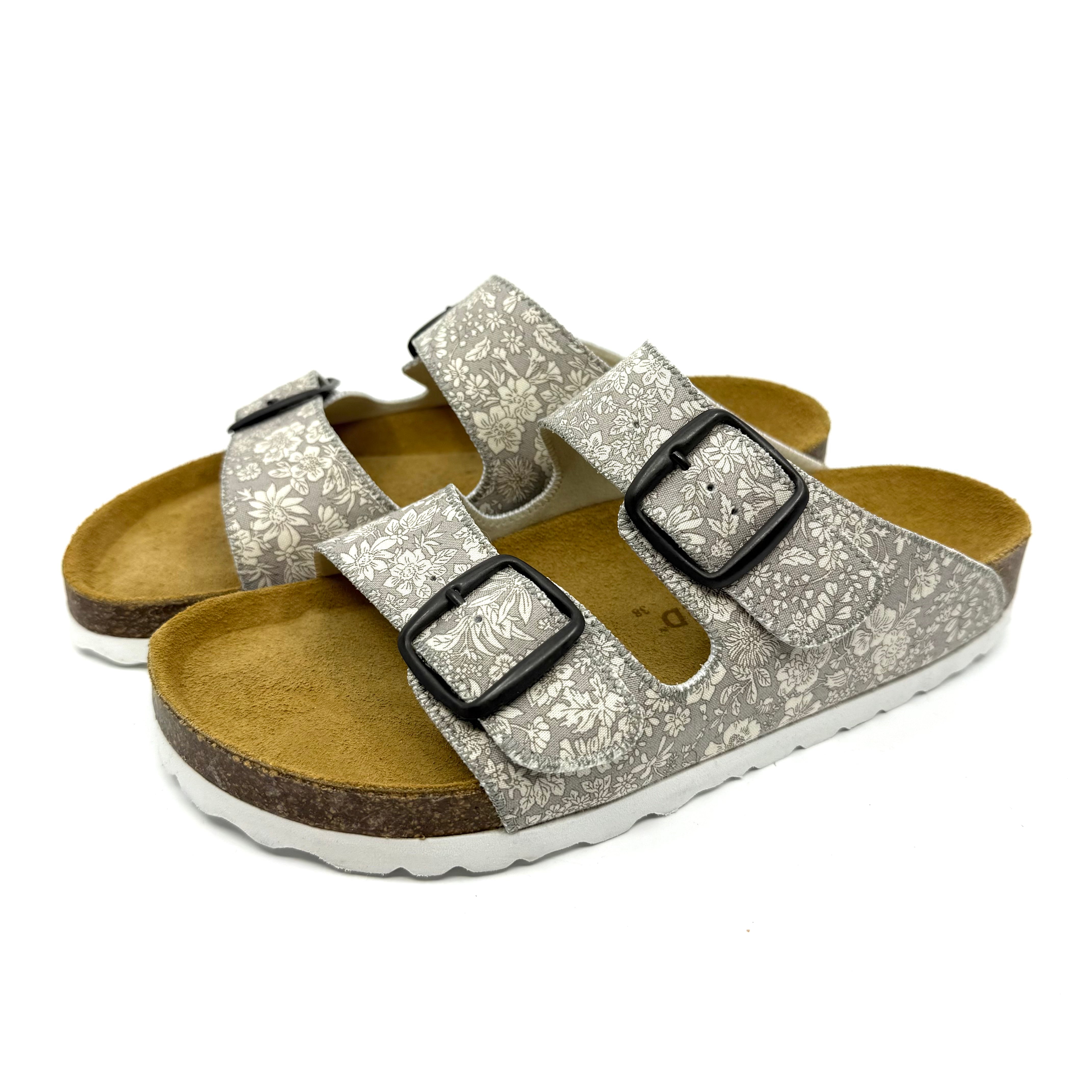Silver glitter sandals with black buckles on a white background