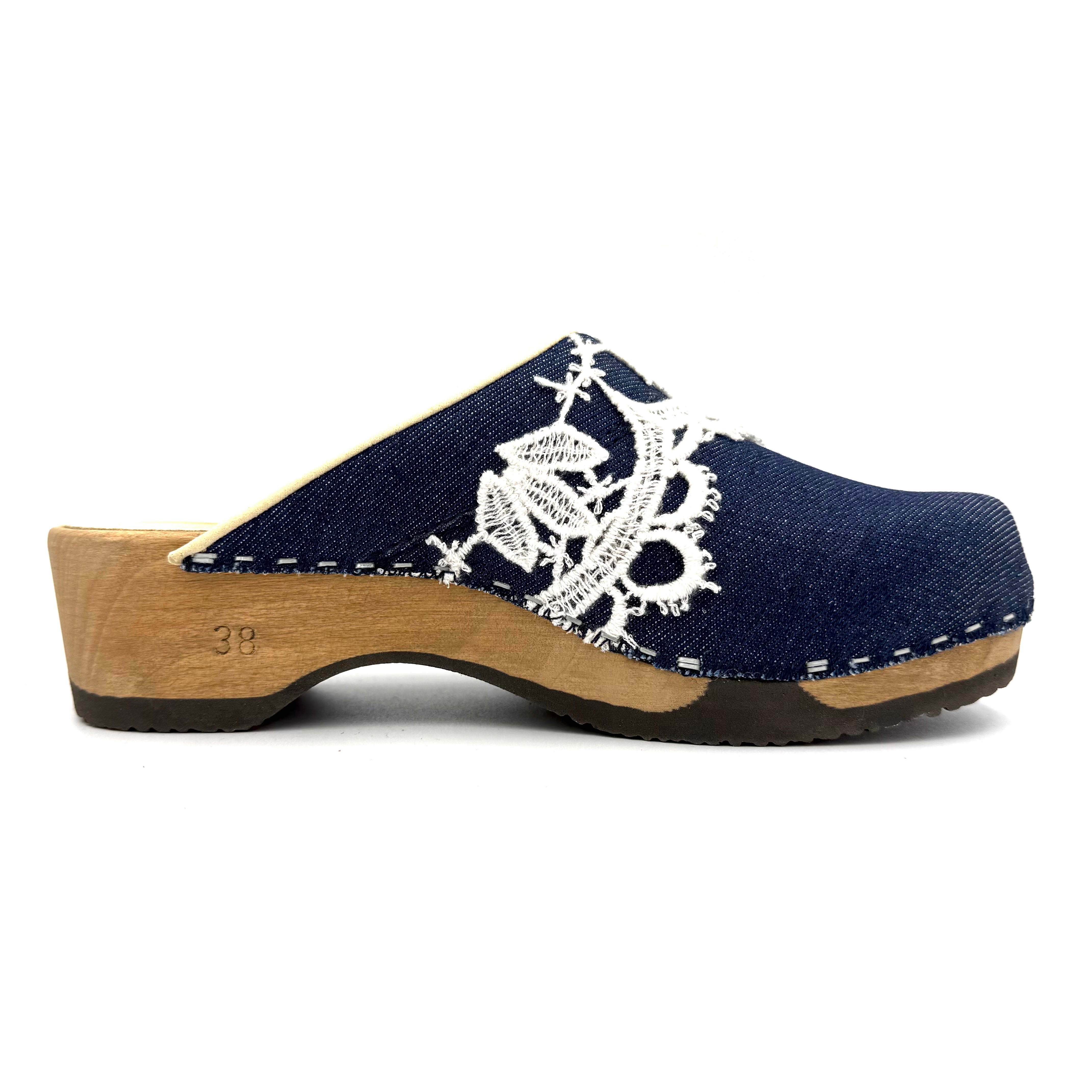 Blue clog shoe with white lace design on a white background