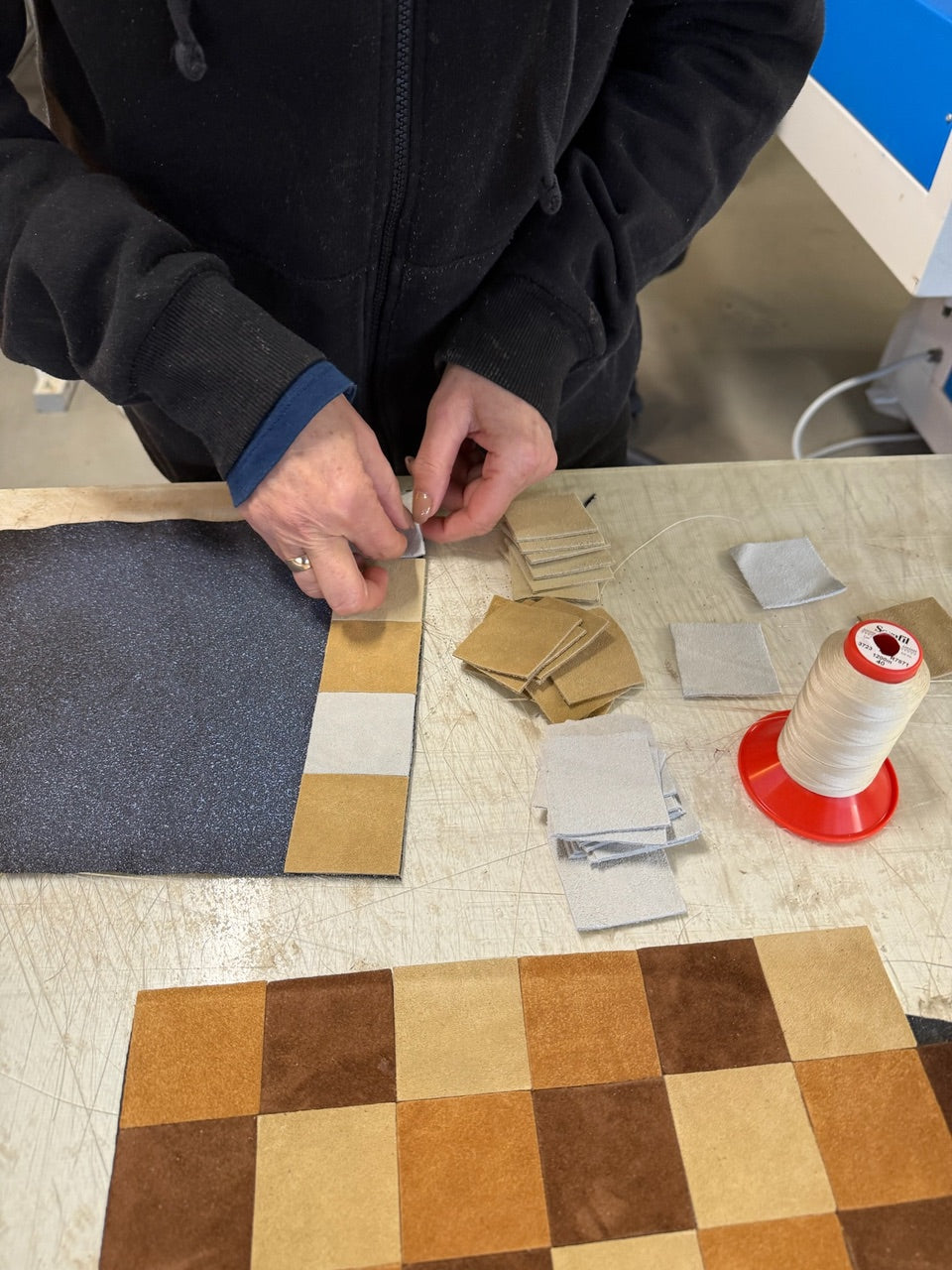 Suede remnants being laid out by hand for a KUNSTEN patchwork pair