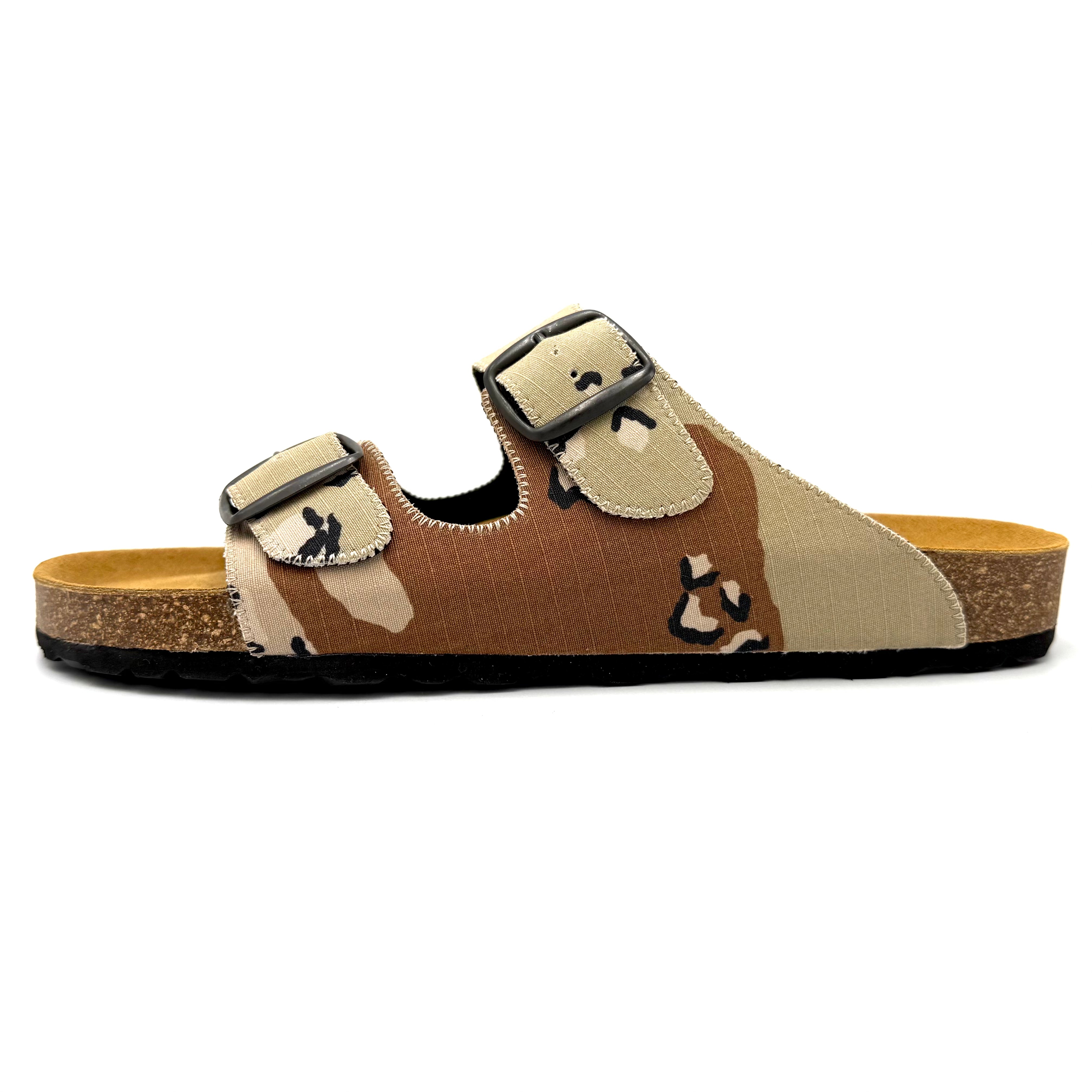Brown sandal with beige accents and a buckle on a white background