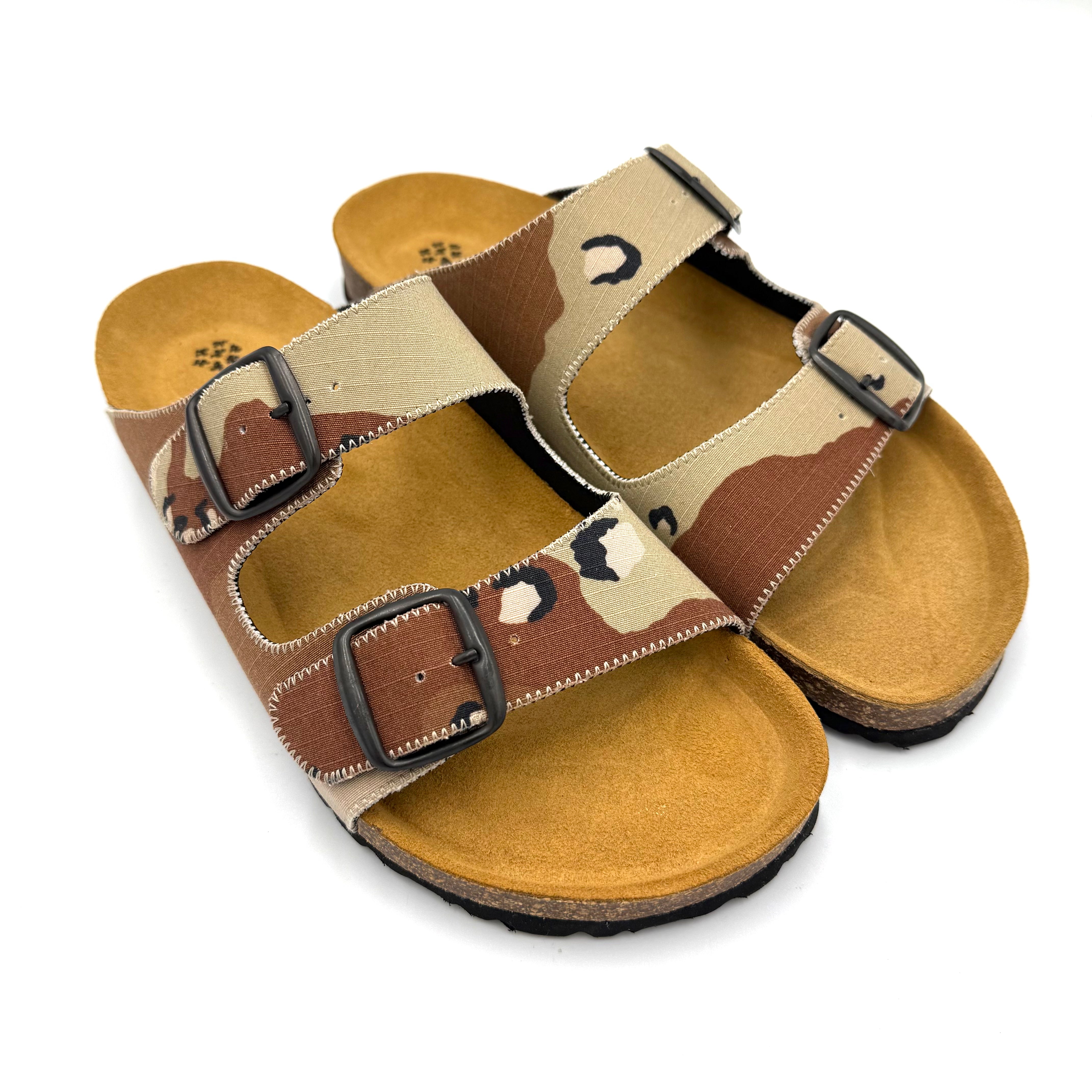 Camouflage-patterned sandals with brown straps on a white background