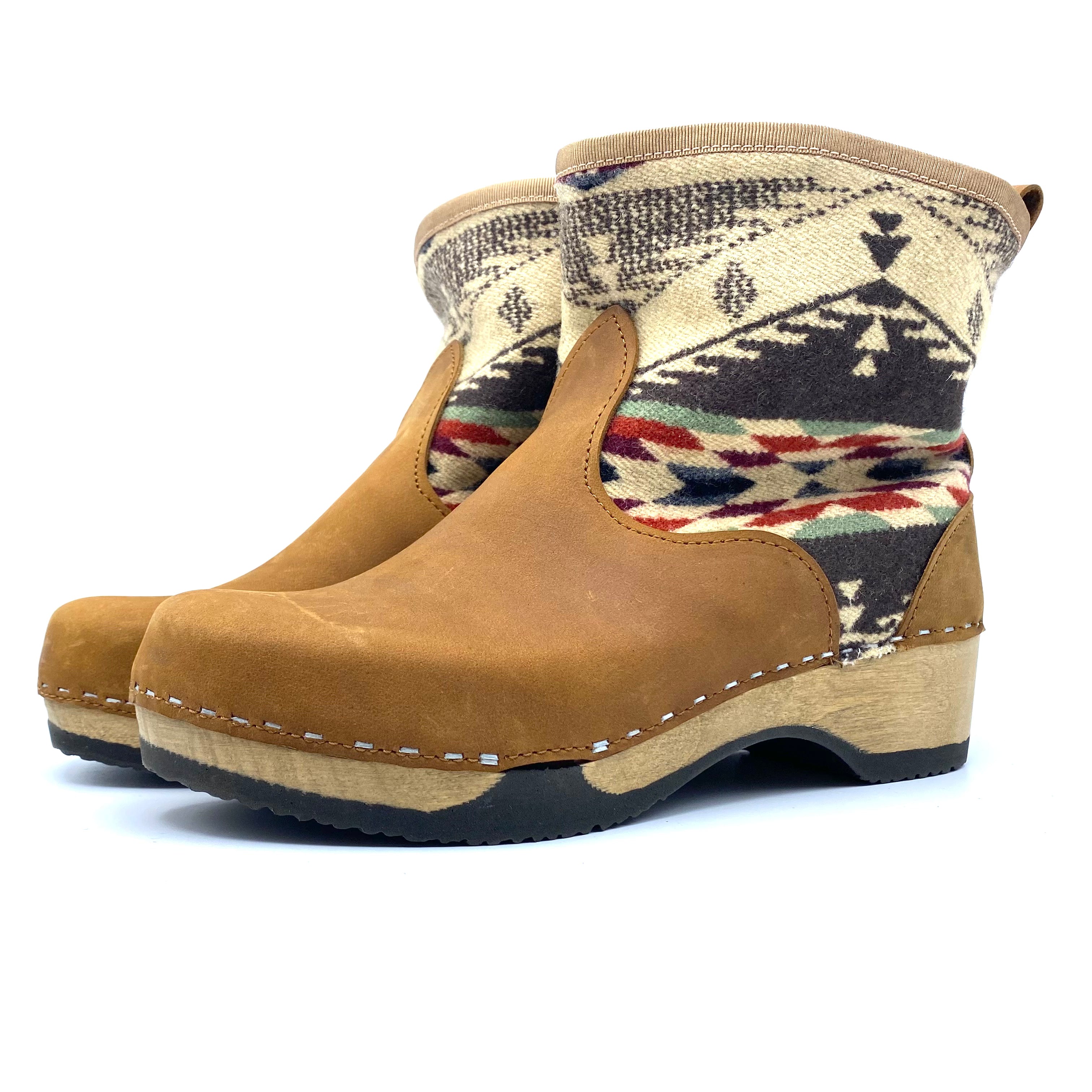 Pair of tan boots with patterned top on a white background