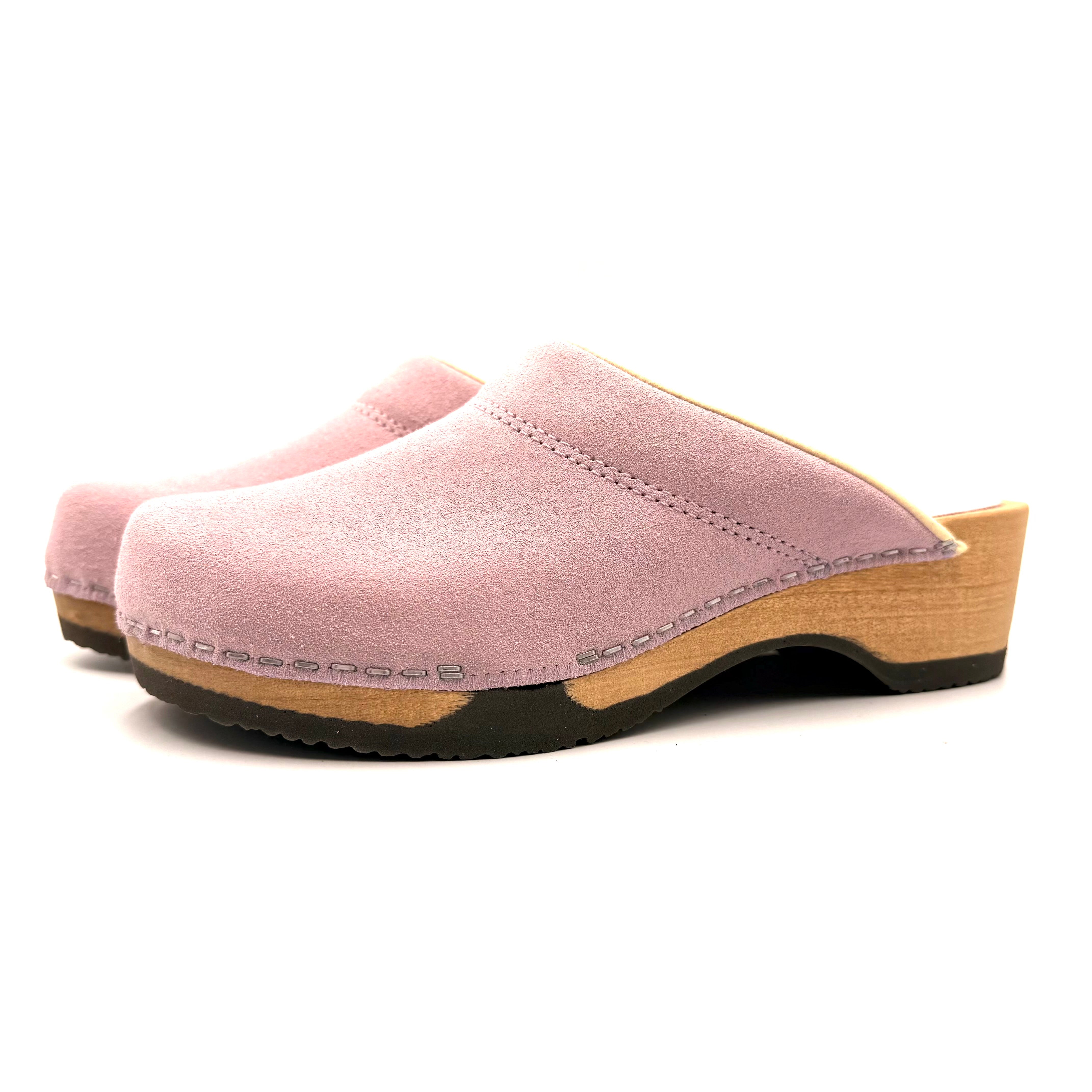 Pink clogs with wooden sole on a white background