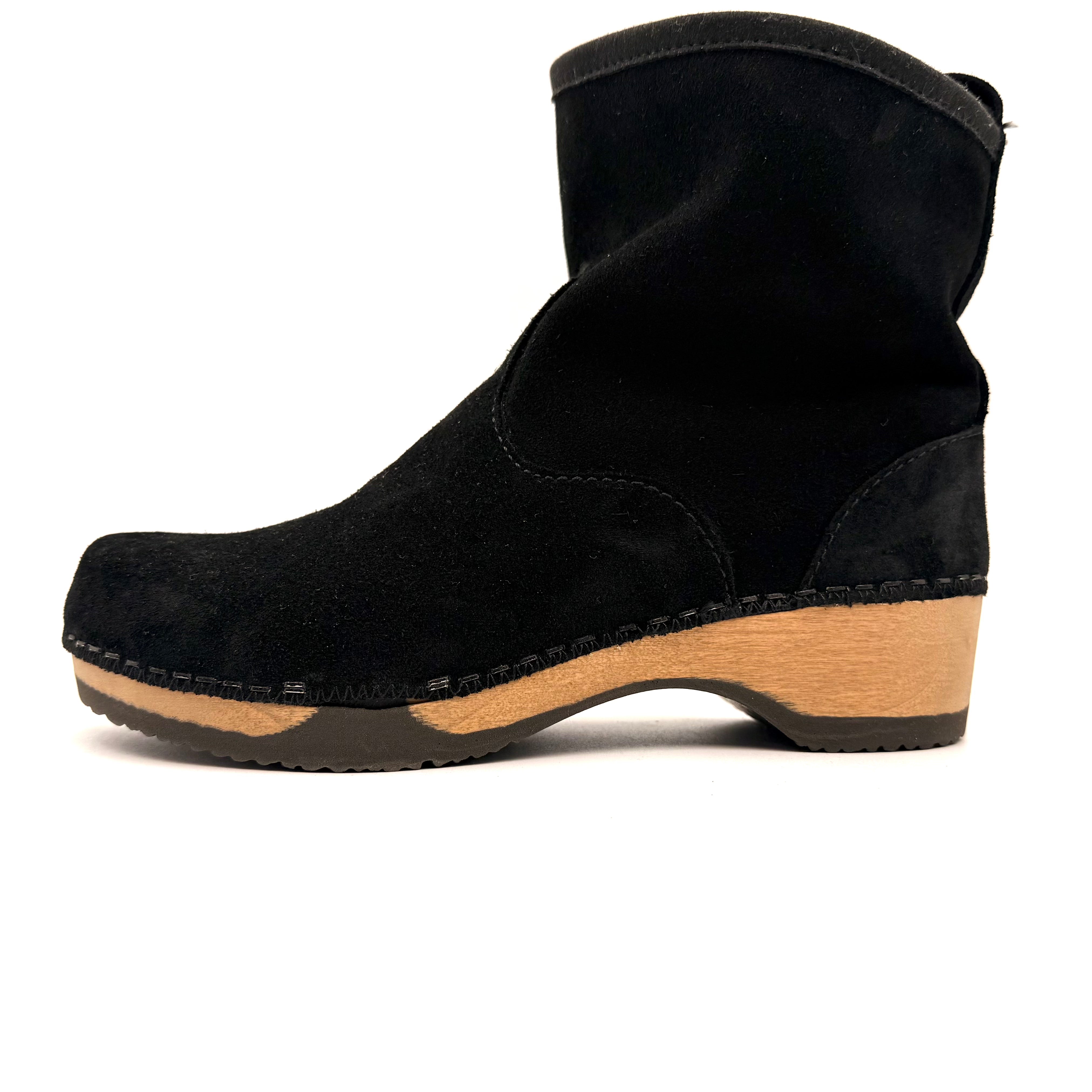Black ankle boot with wooden sole on a white background