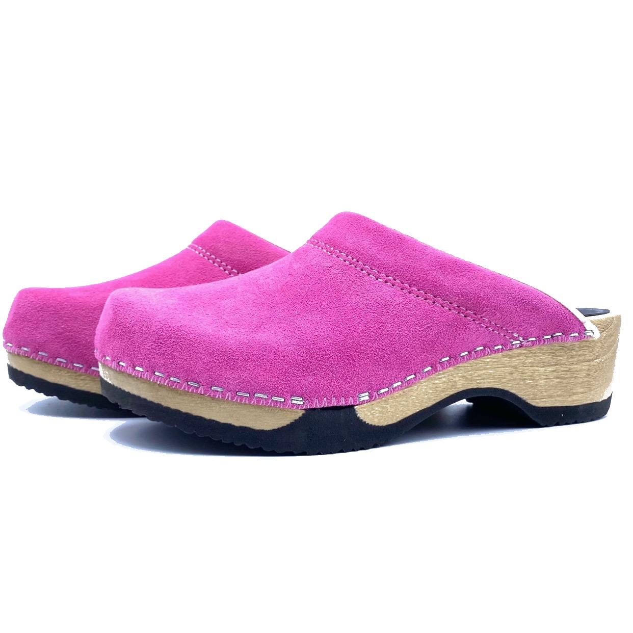 Pair of pink clogs with wooden soles on a white background