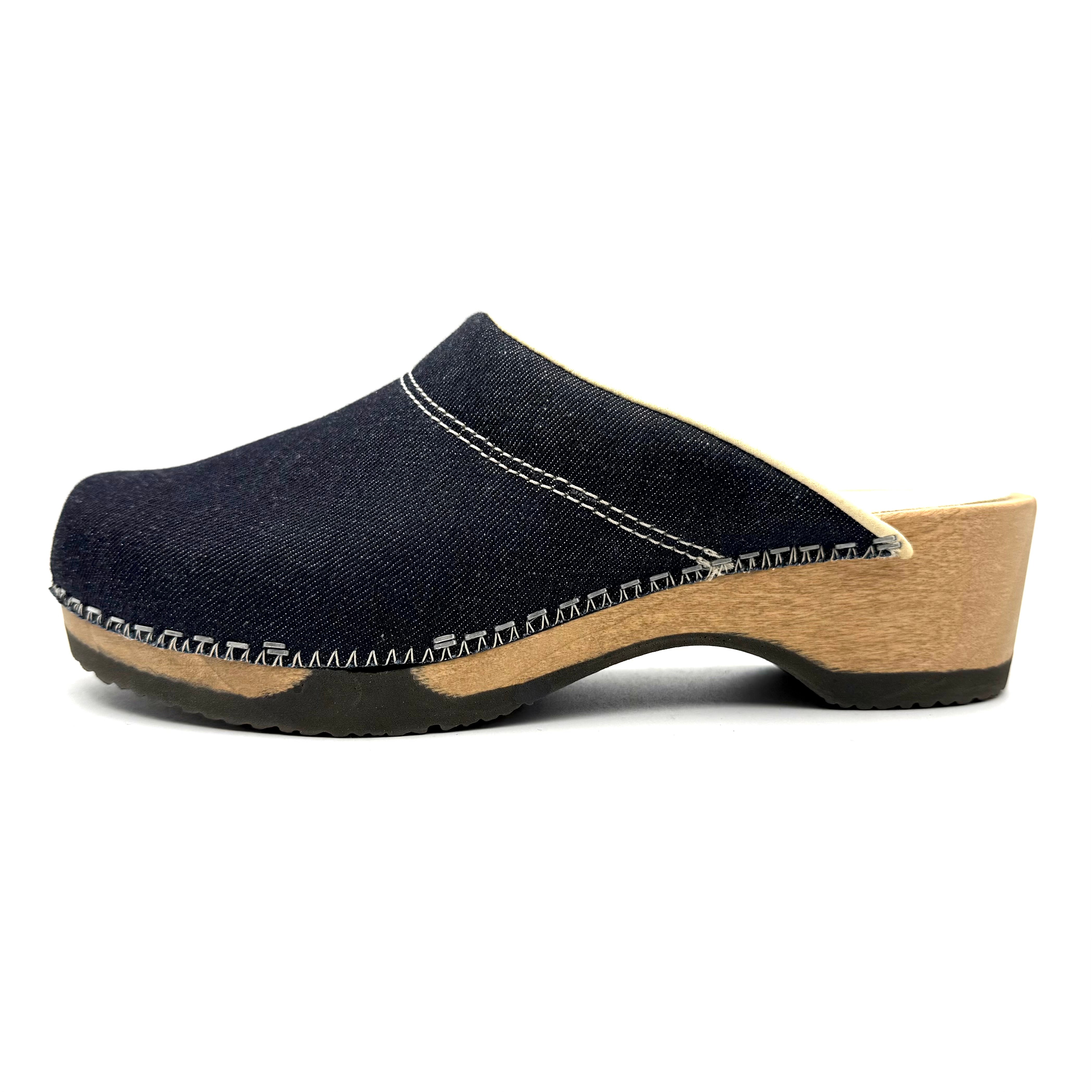 Blue denim clog shoe with wooden sole on a white background