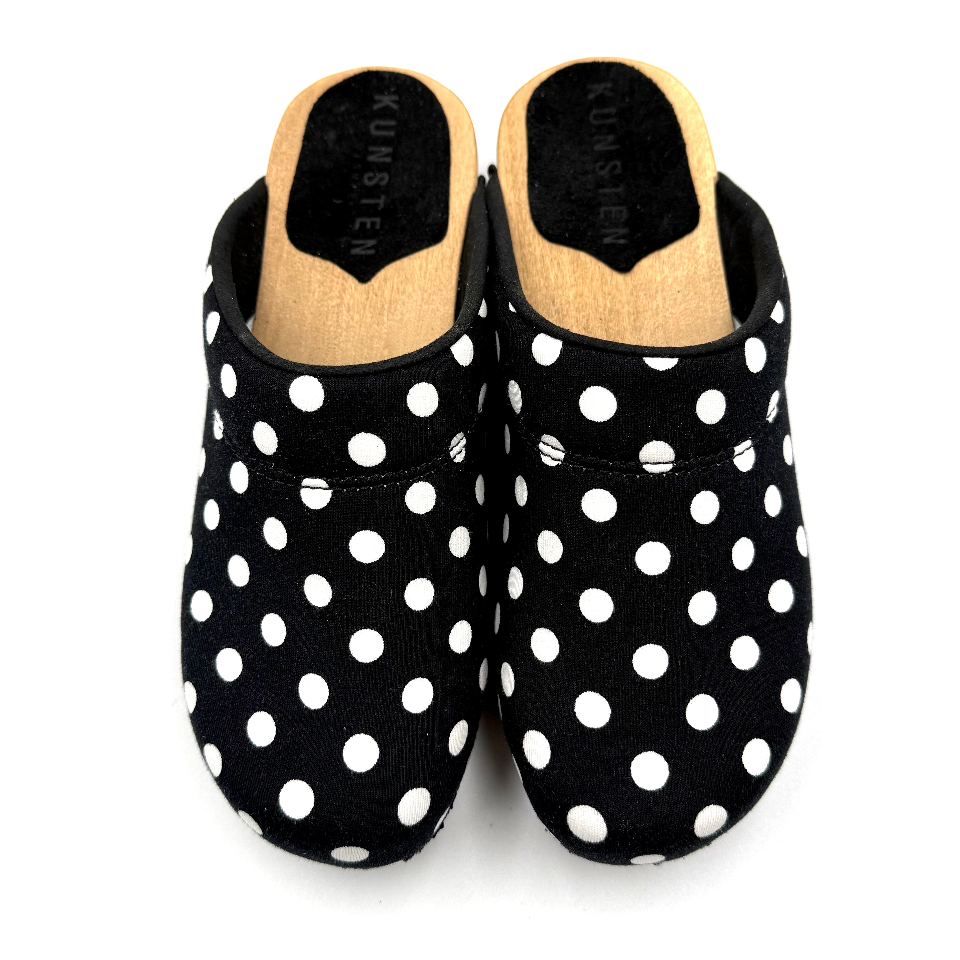 Black slippers with white polka dots on a white background