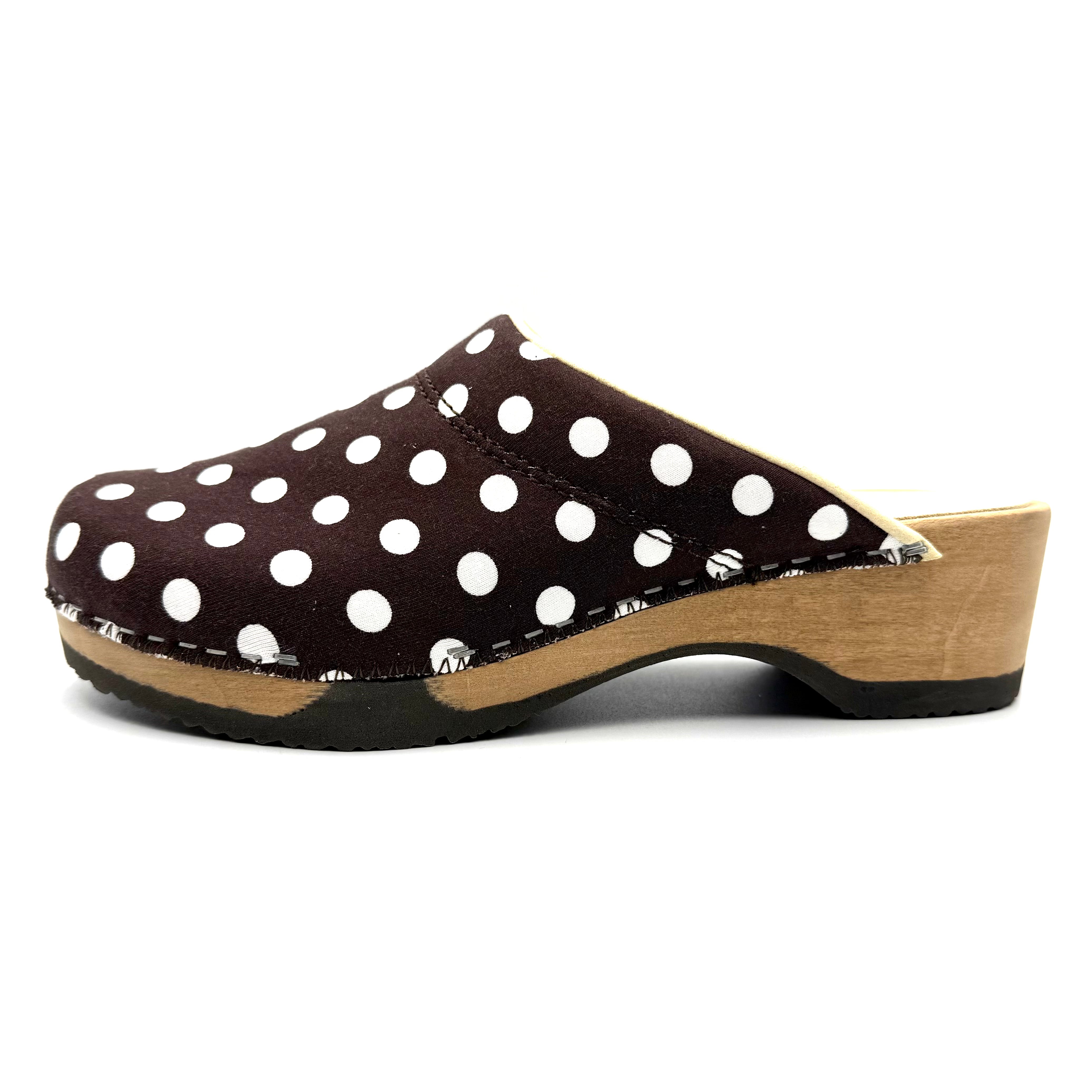 Polka dot clog shoe with wooden sole on a white background