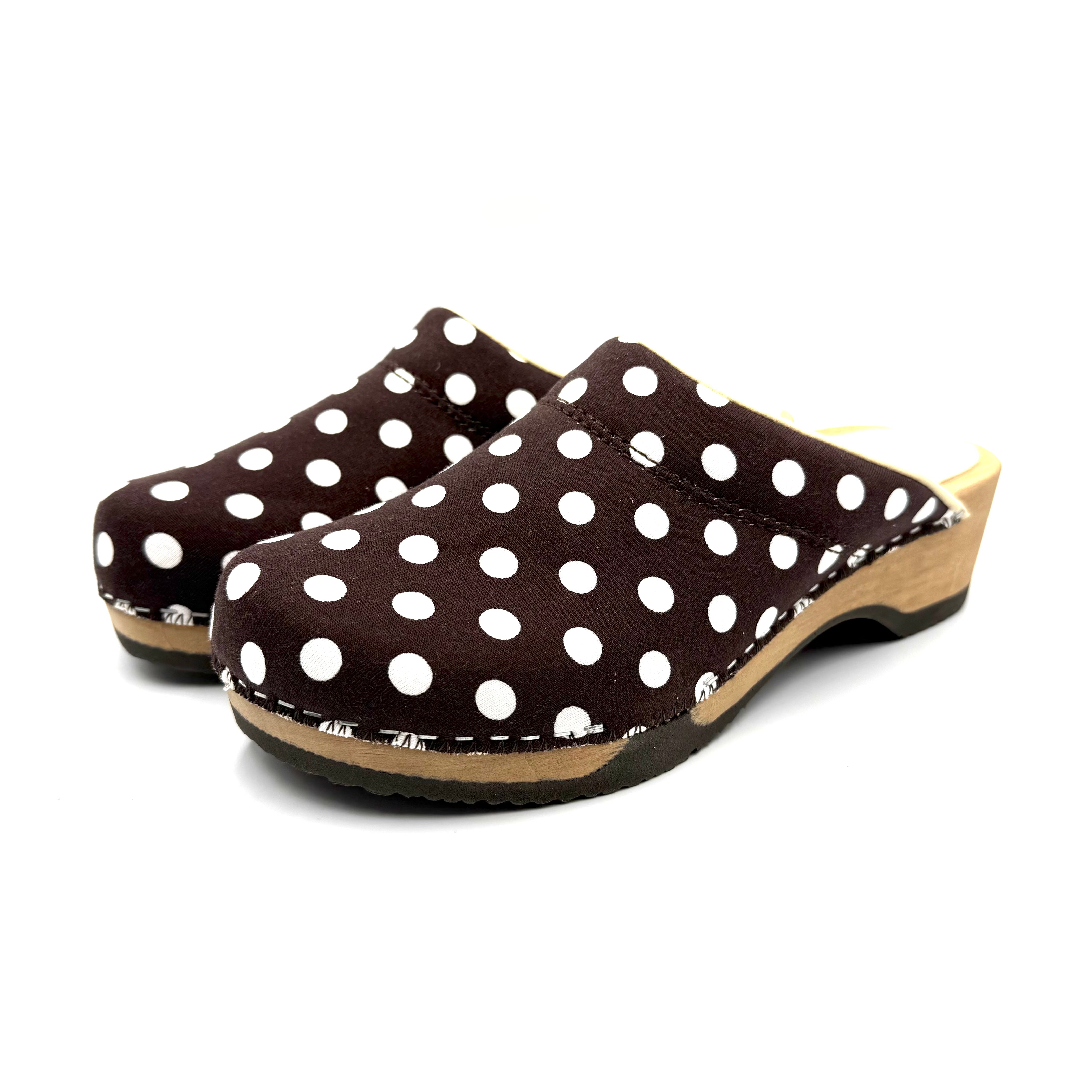 Pair of brown clogs with white polka dots on a white background