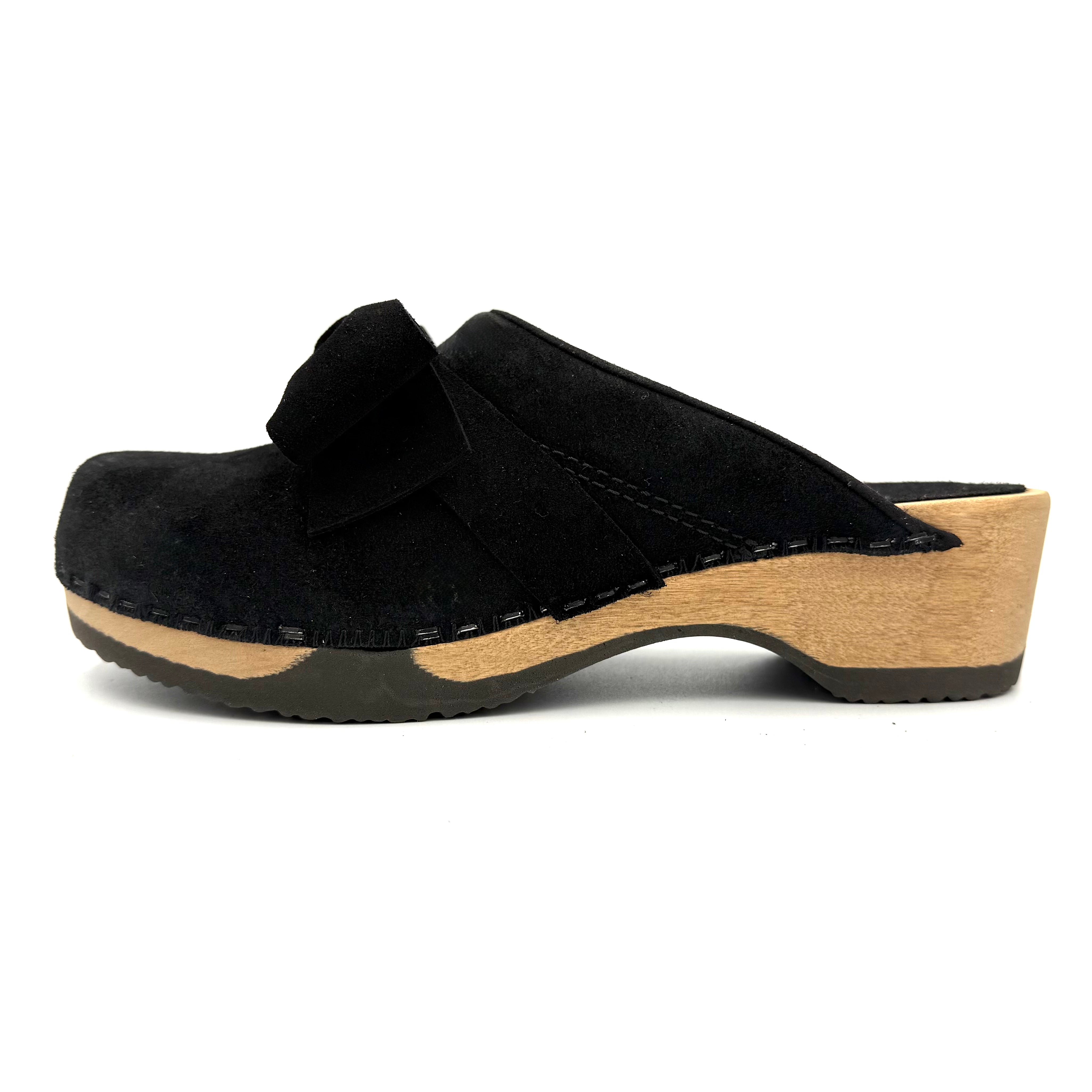 Black suede clog shoe with wooden sole on a white background