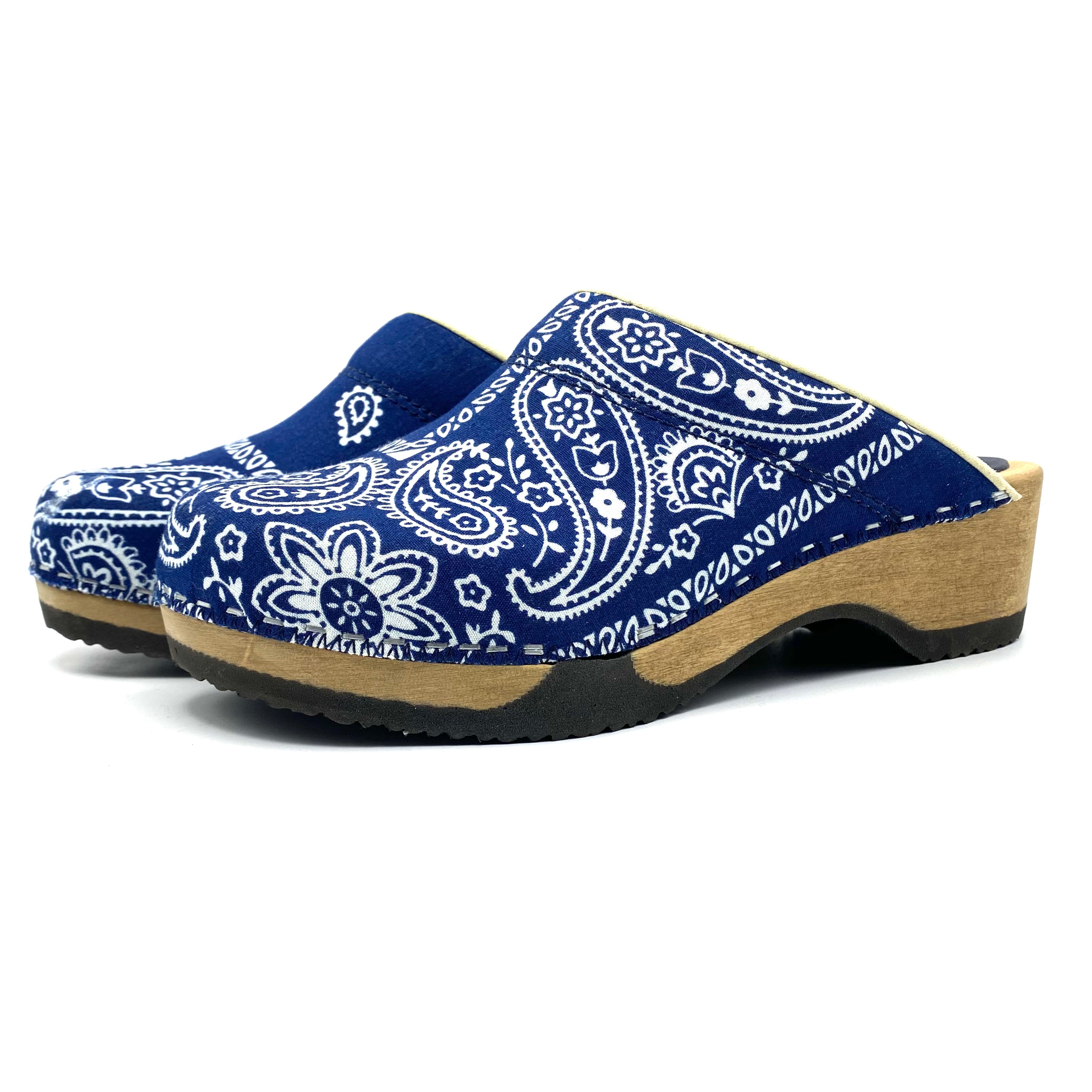 Blue and white patterned clogs on a white background