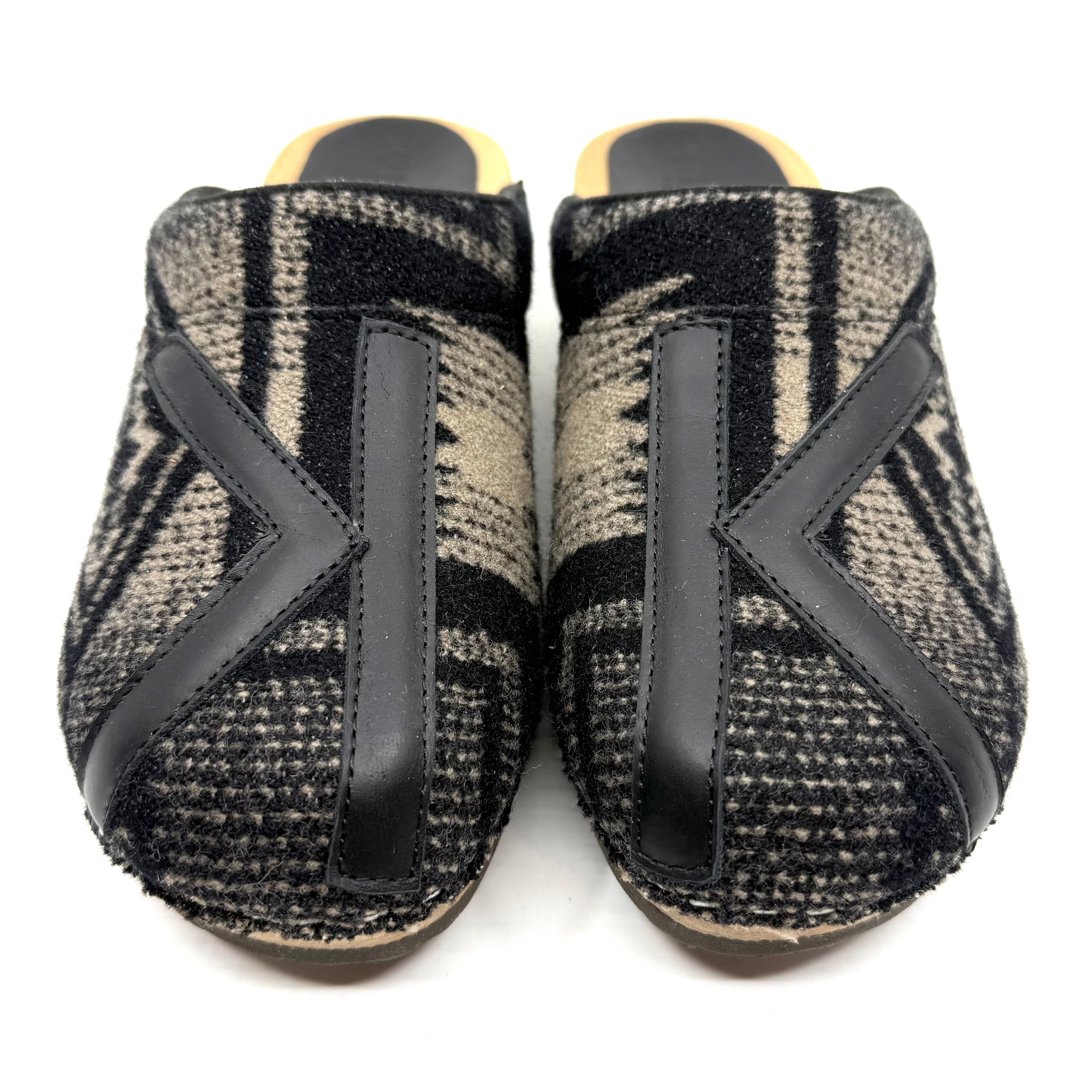 Pair of black and gray patterned slippers on a white background