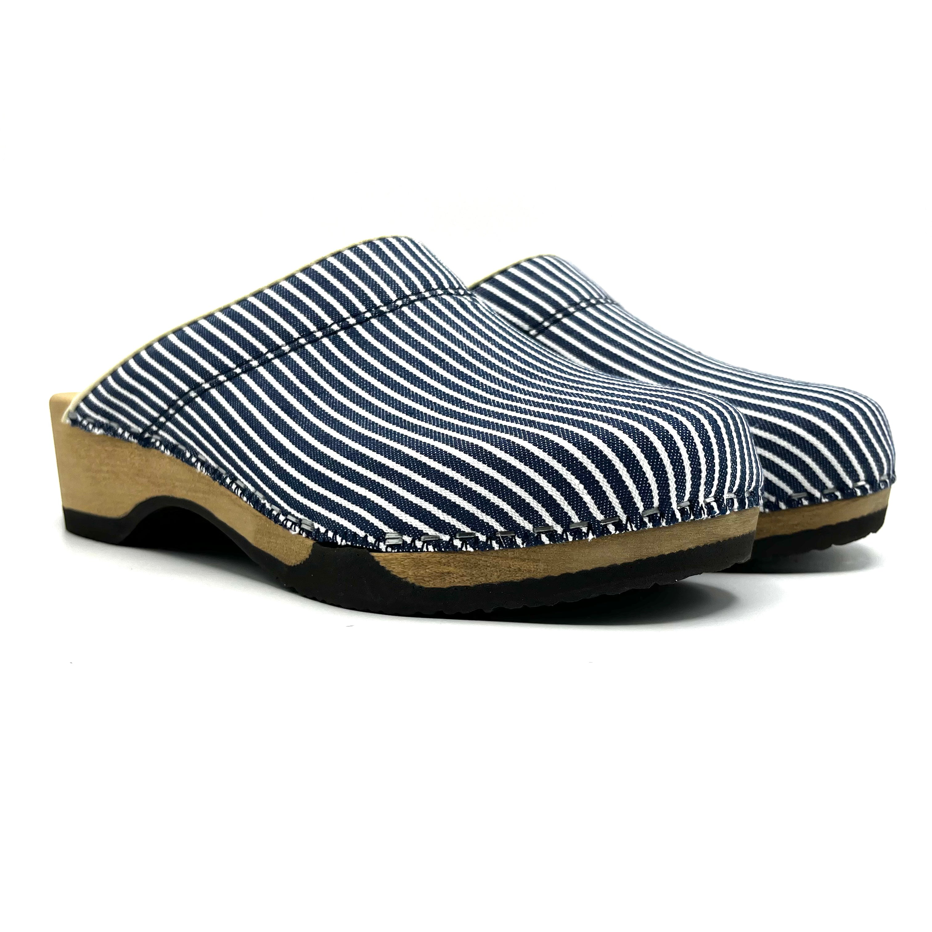 Clog shoe with striped blue and white upper and wooden sole on a white background