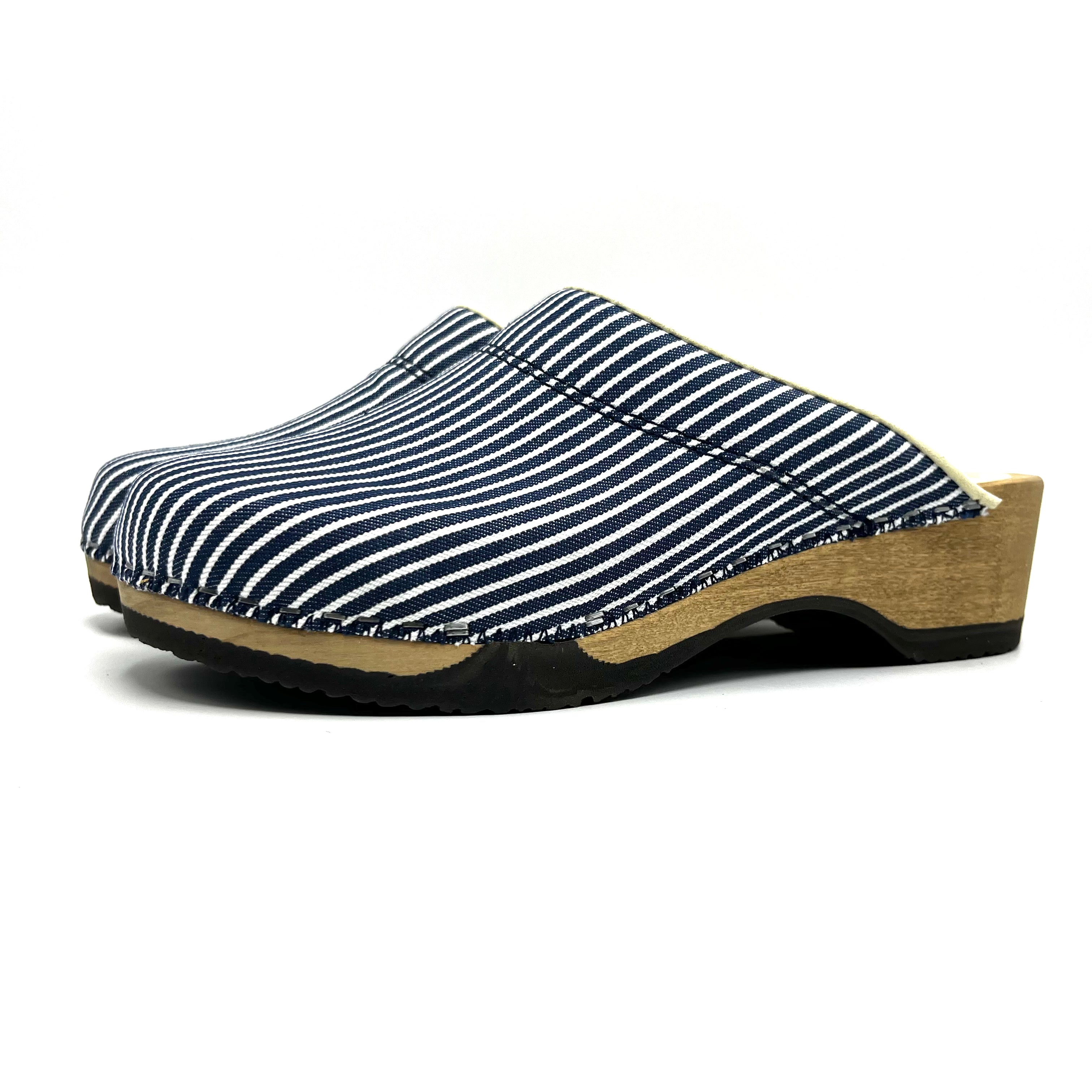 Clog shoe with striped blue and white upper and wooden sole on a white background