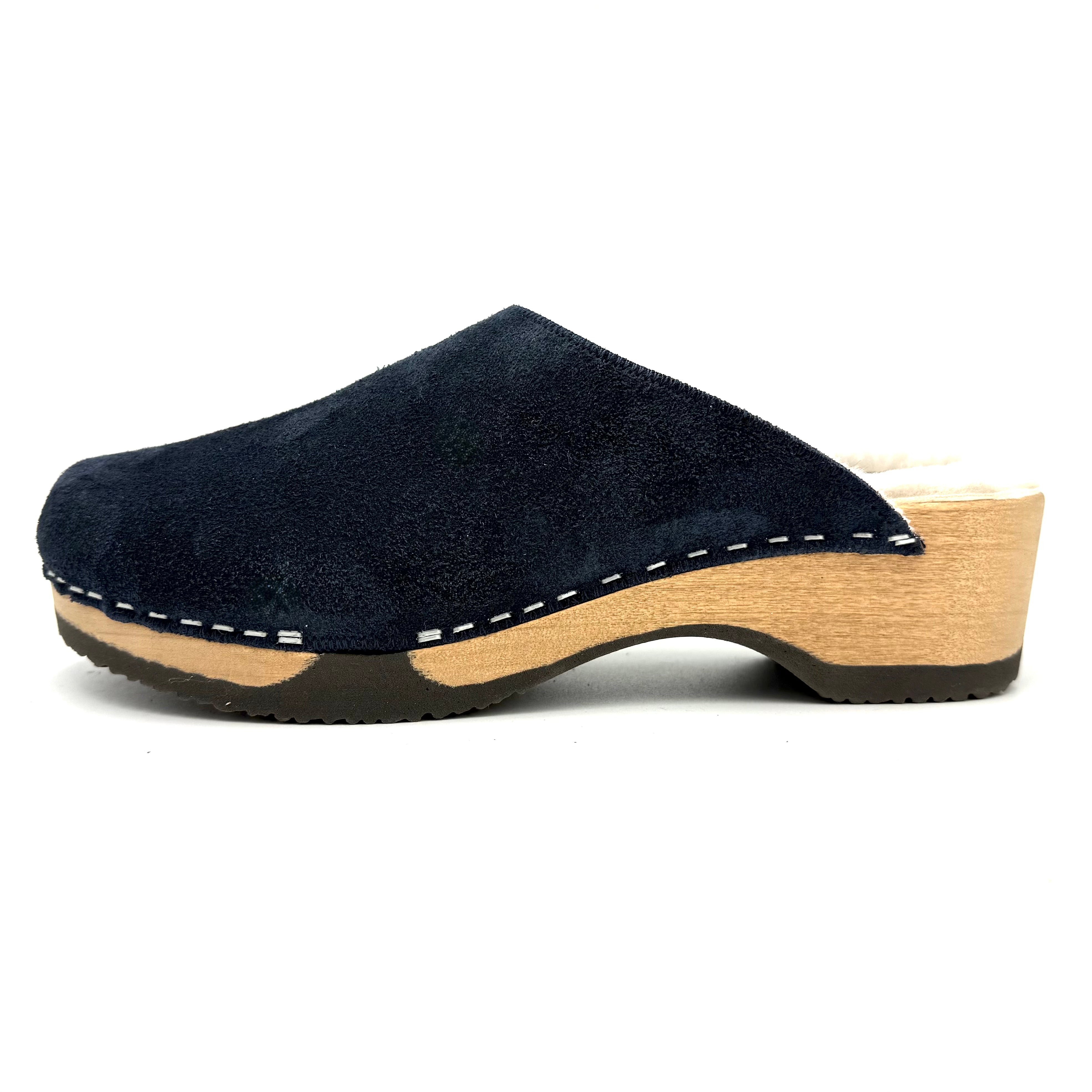 Navy blue suede clog shoe with wooden sole on a white background