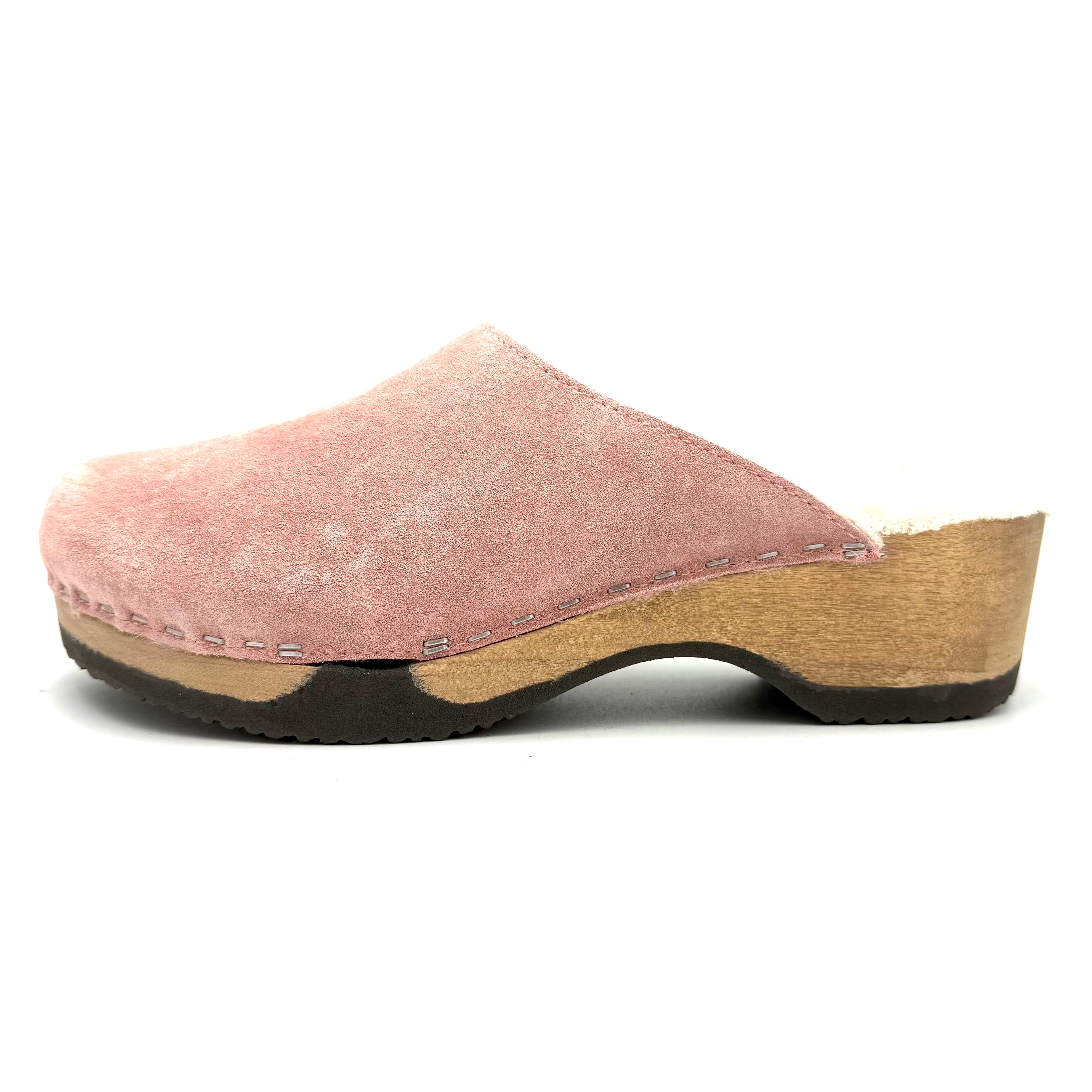 Pink clog shoe with wooden sole on a white background