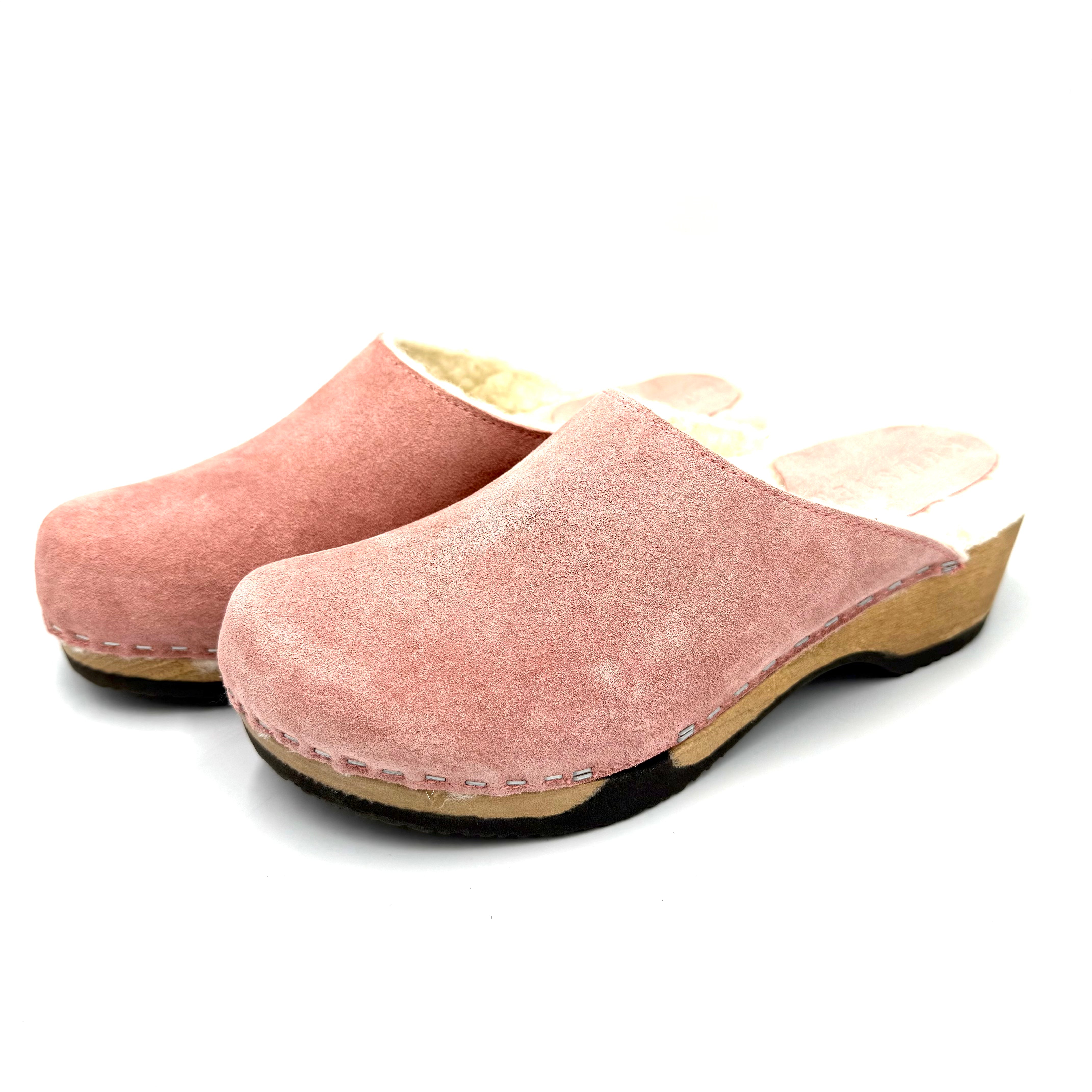 Pair of pink clogs on a white background