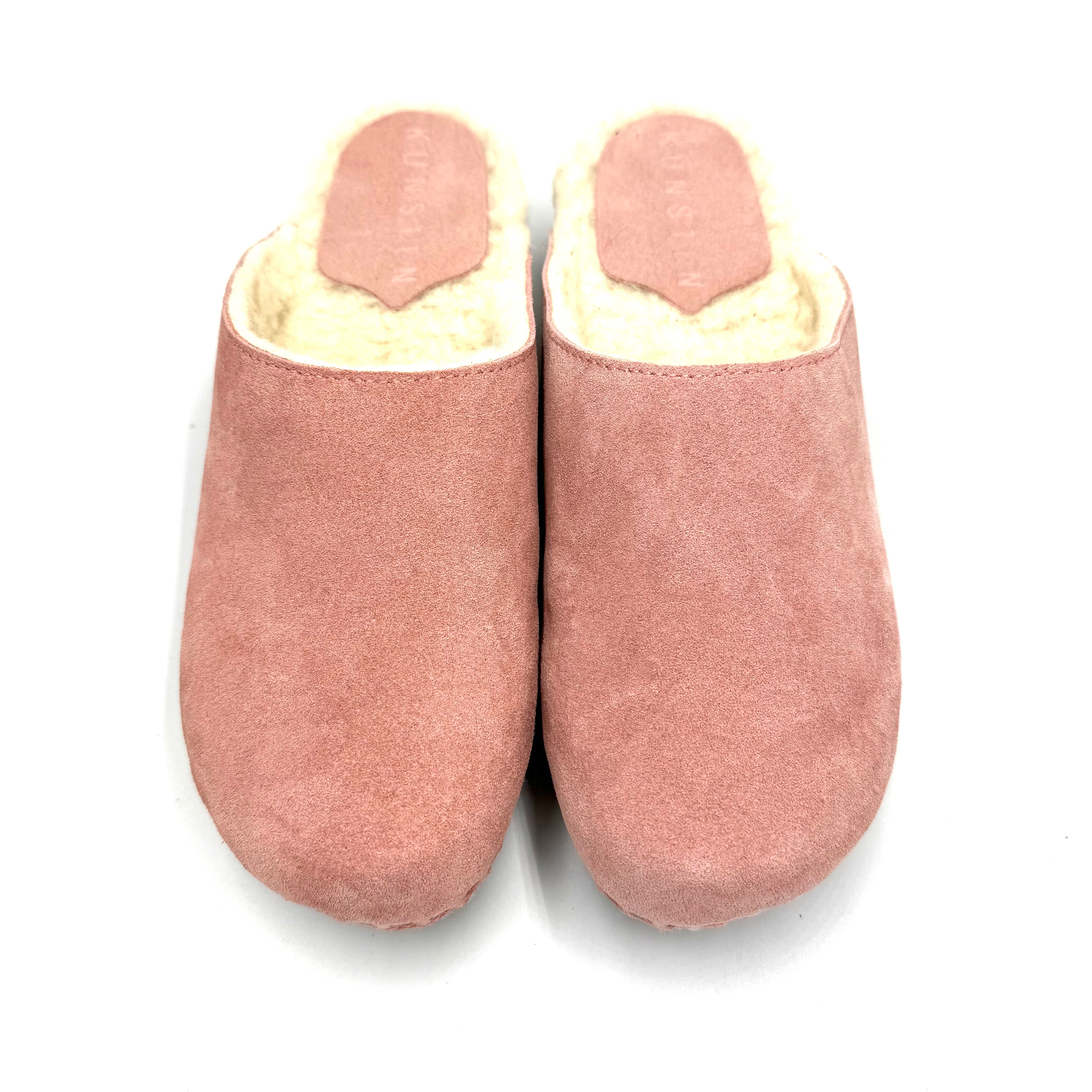 Pair of pink slippers with white lining on a white background