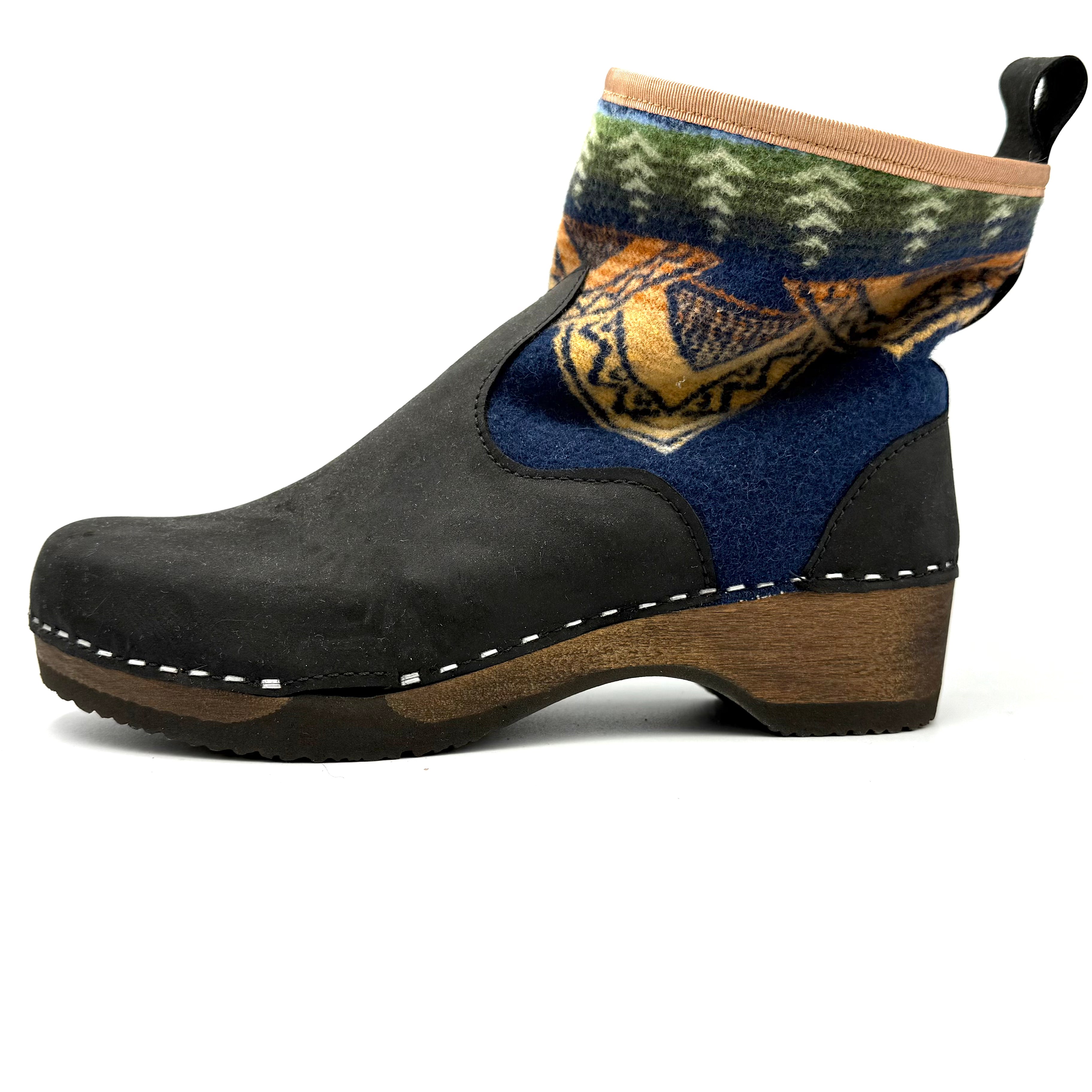 Black clog shoe with patterned sock on a white background