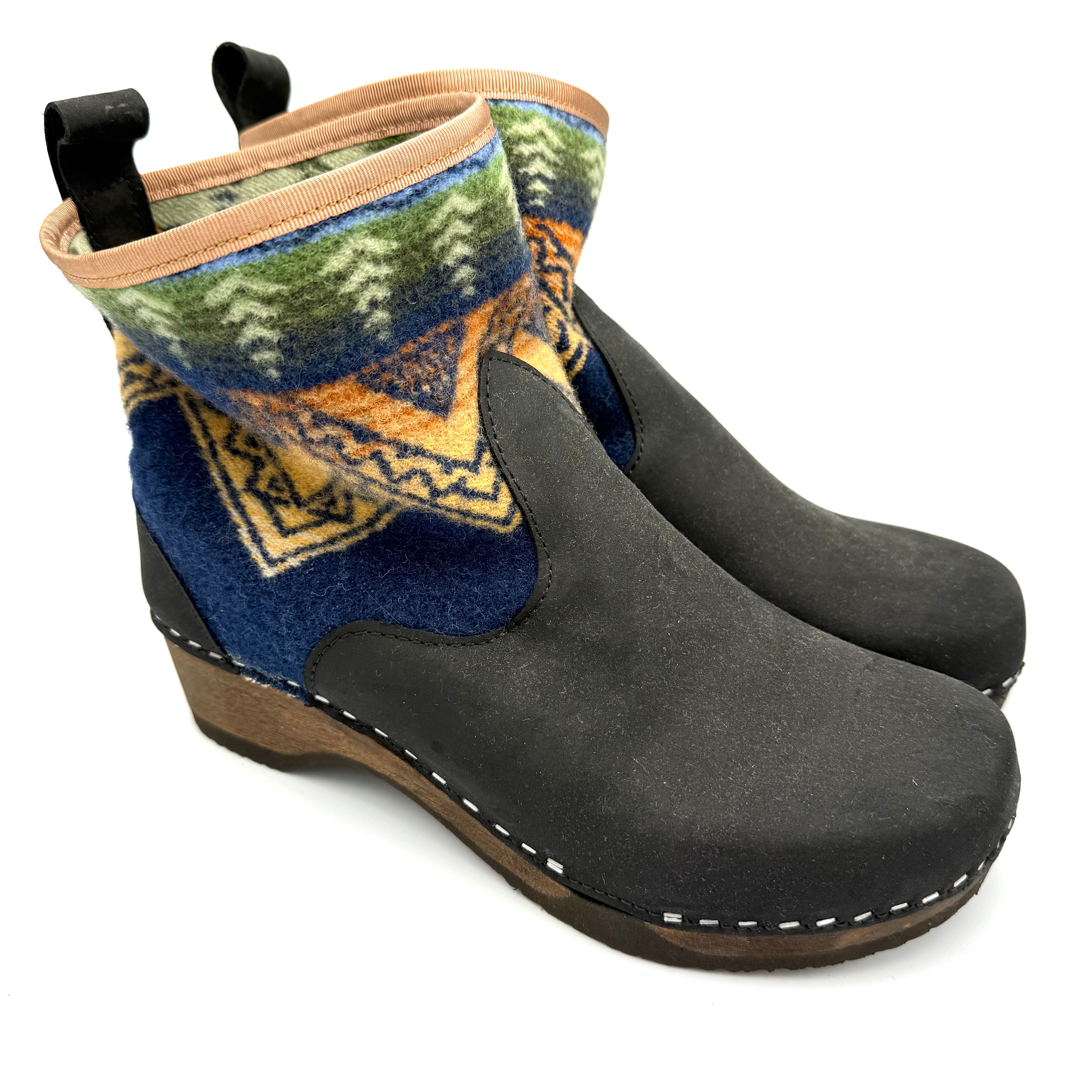 Black clog-style shoes with patterned insole on a white background