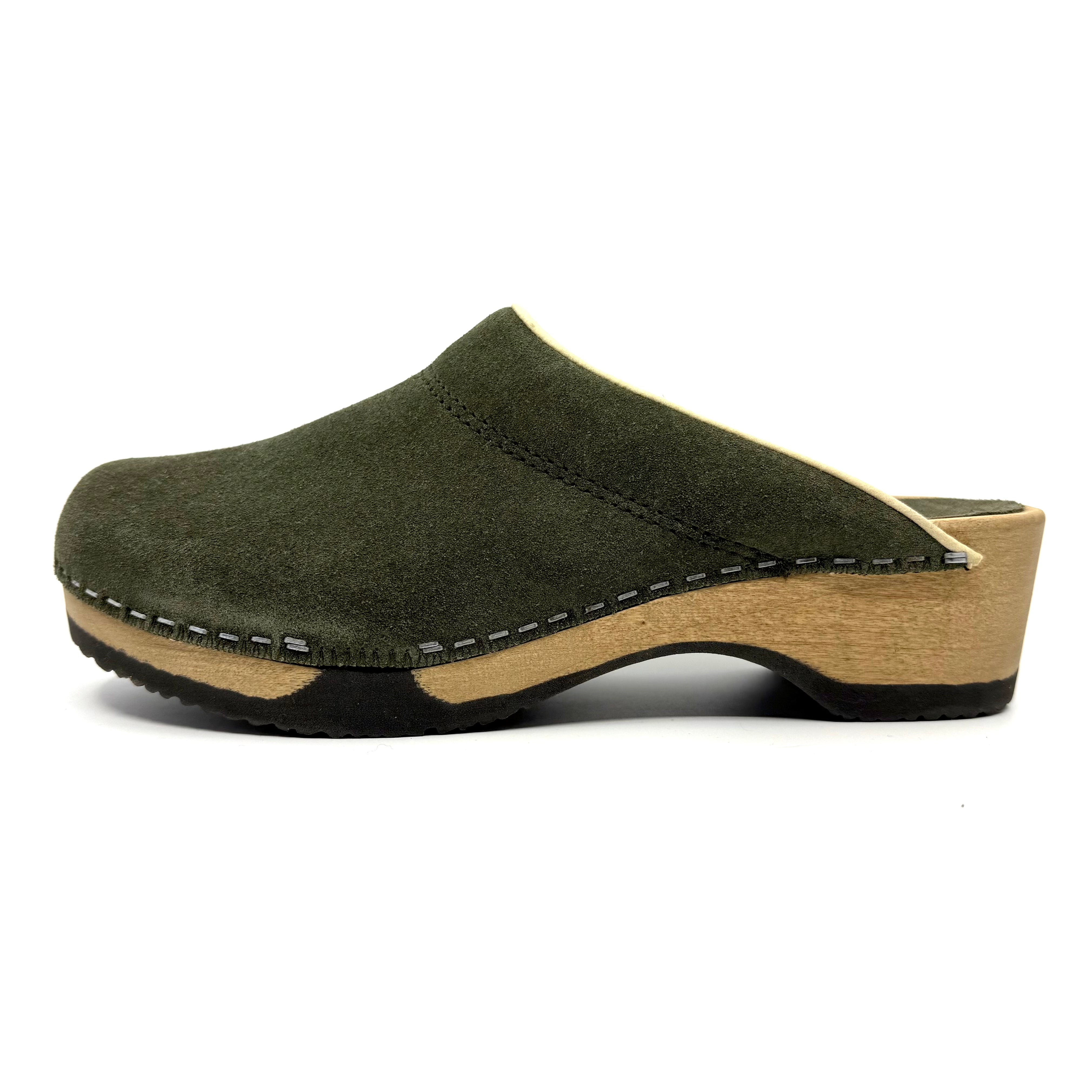 Green suede clog shoe with wooden sole on a white background