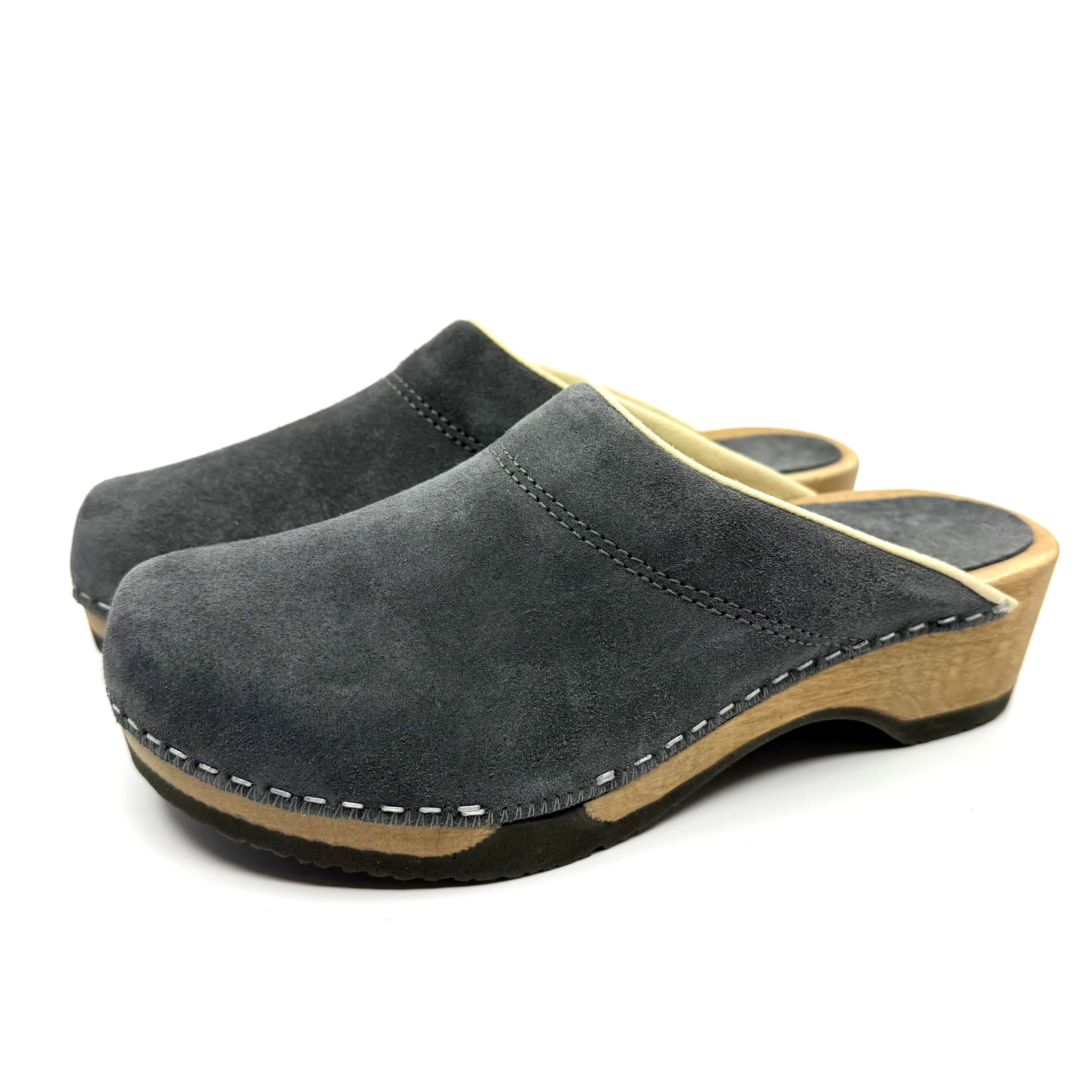 Pair of gray suede clogs with wooden soles on a white background