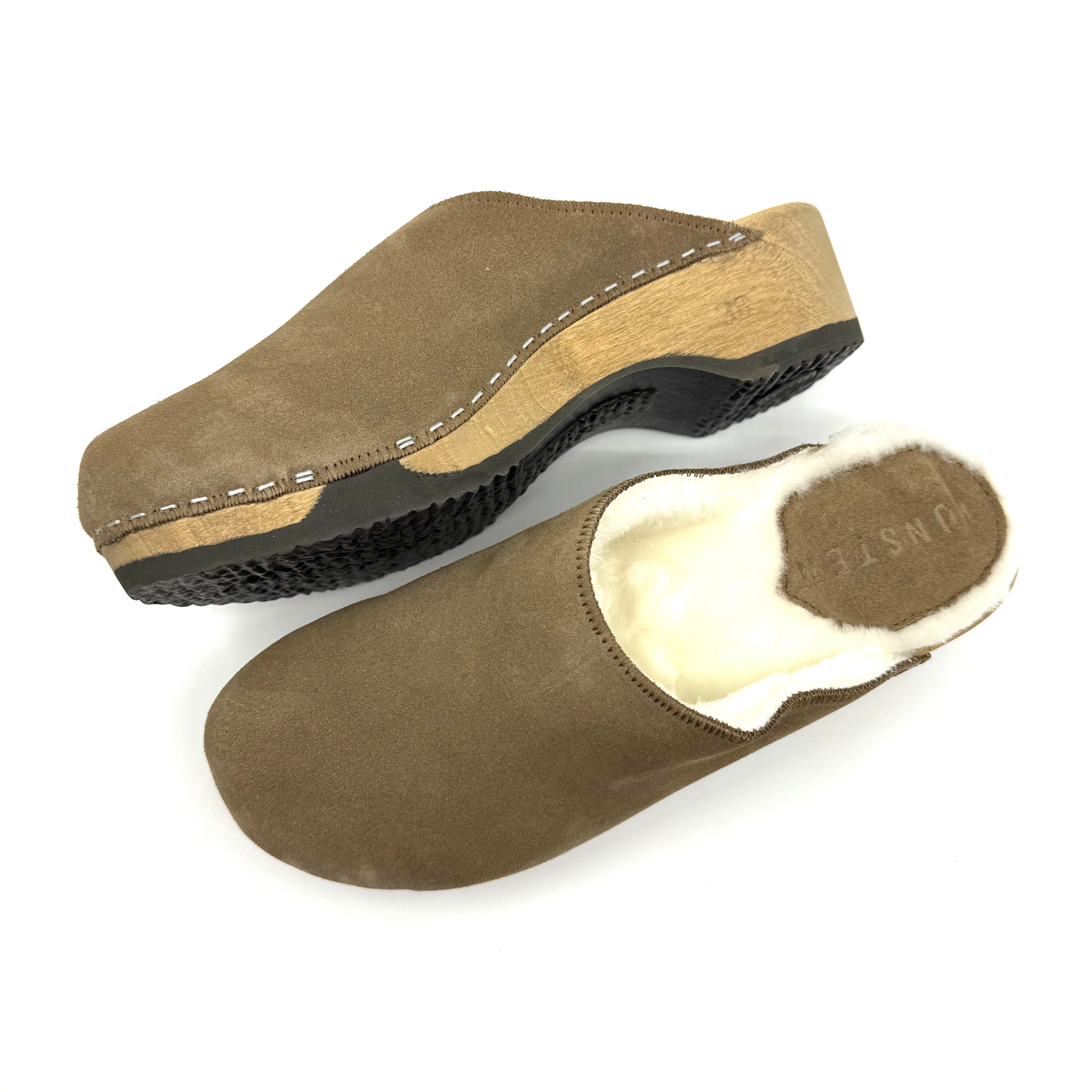 Pair of brown suede clogs with wooden sole on a white background