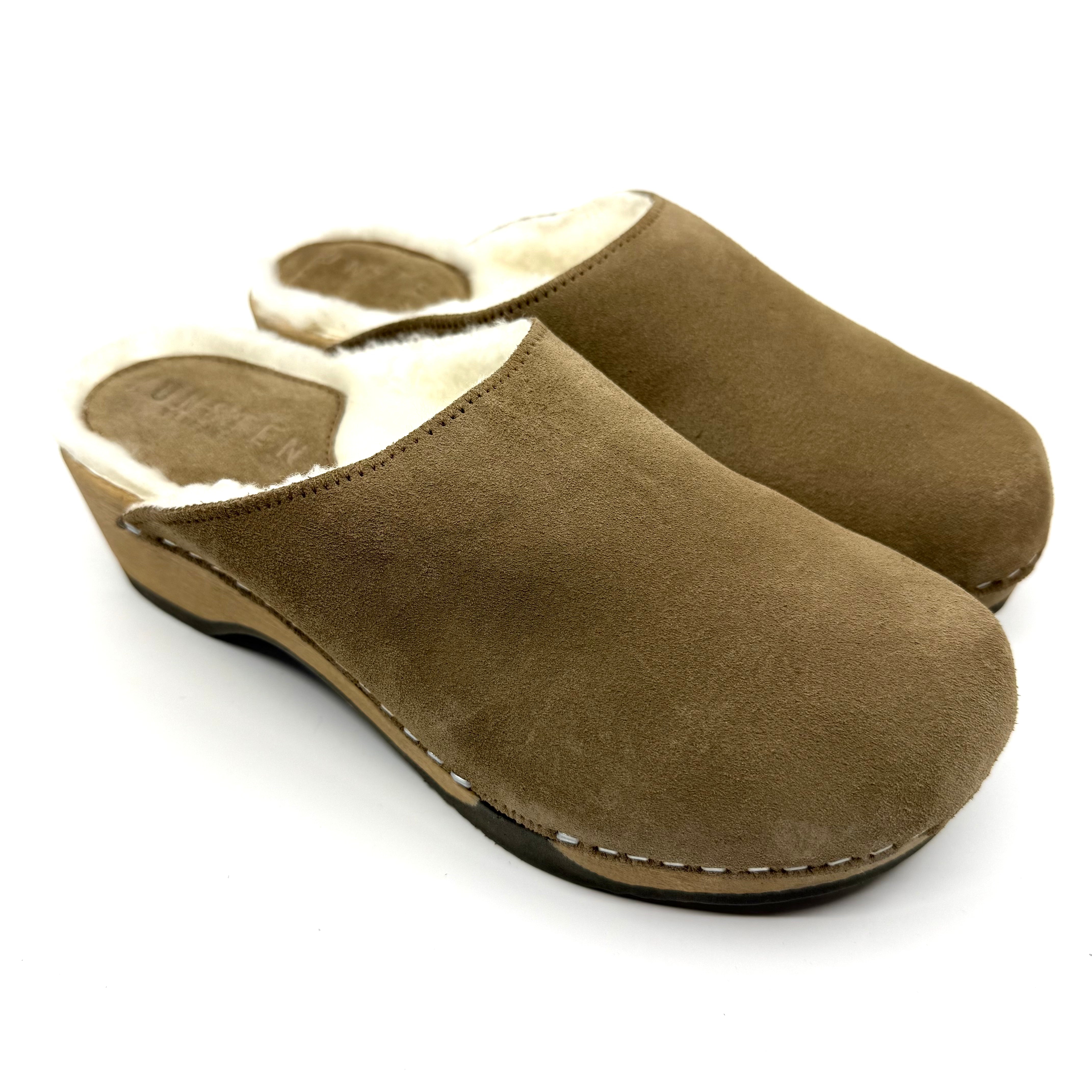 Pair of brown suede clogs on a white background