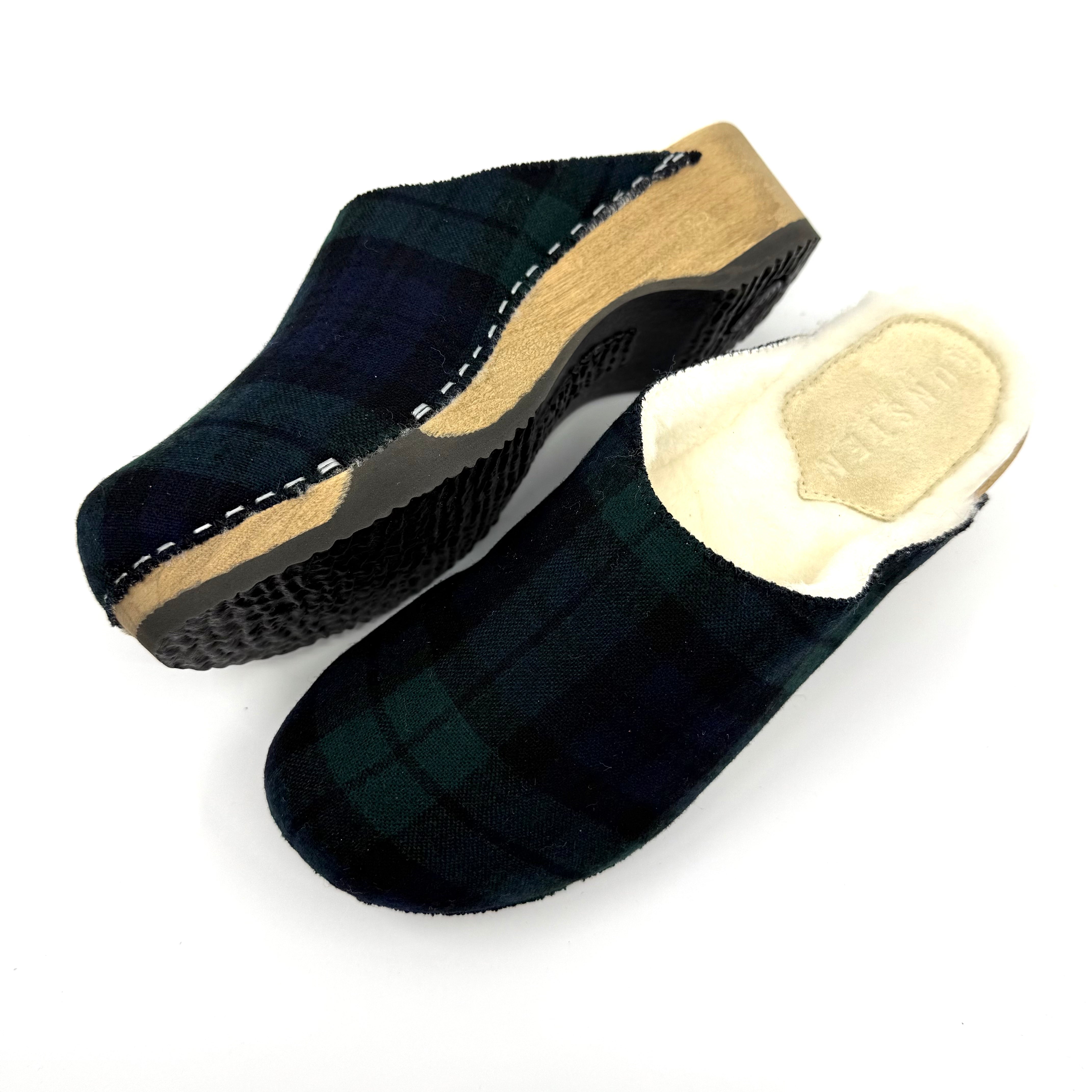 Black slippers with beige soles on a white background