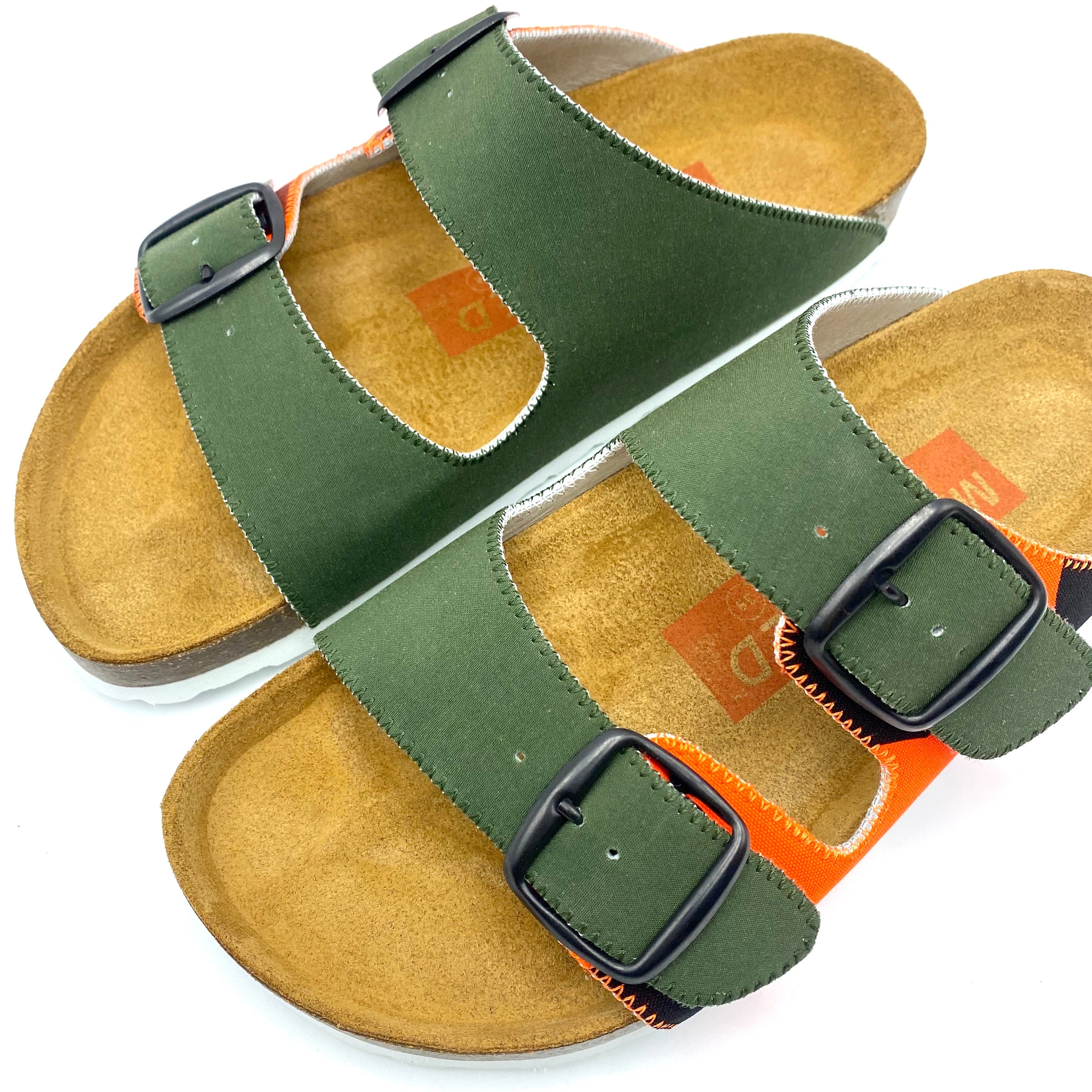 Green sandals with black straps on a white background