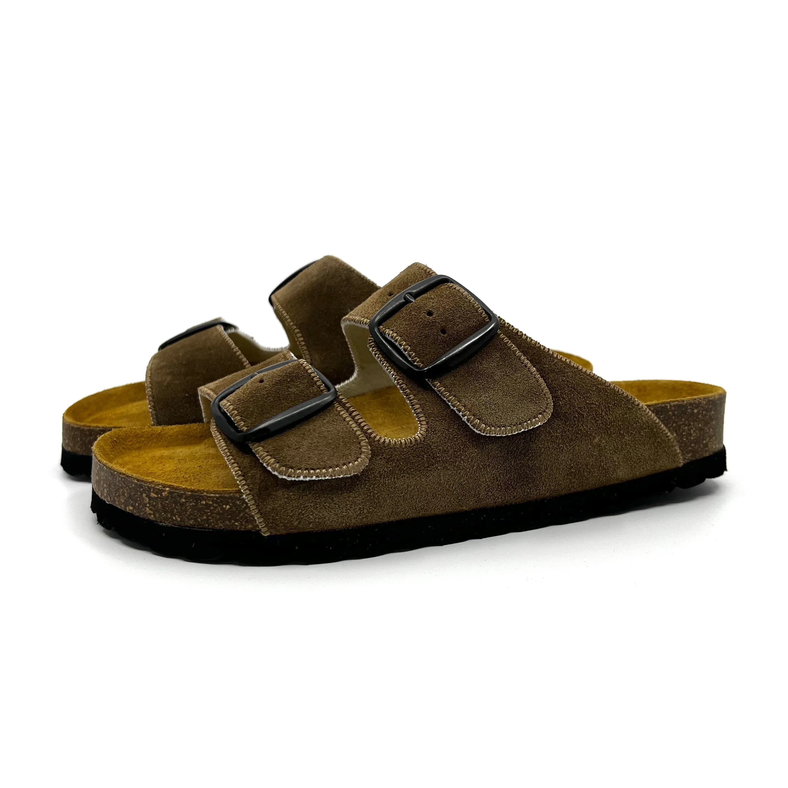 Brown suede sandals with black buckles on a white background