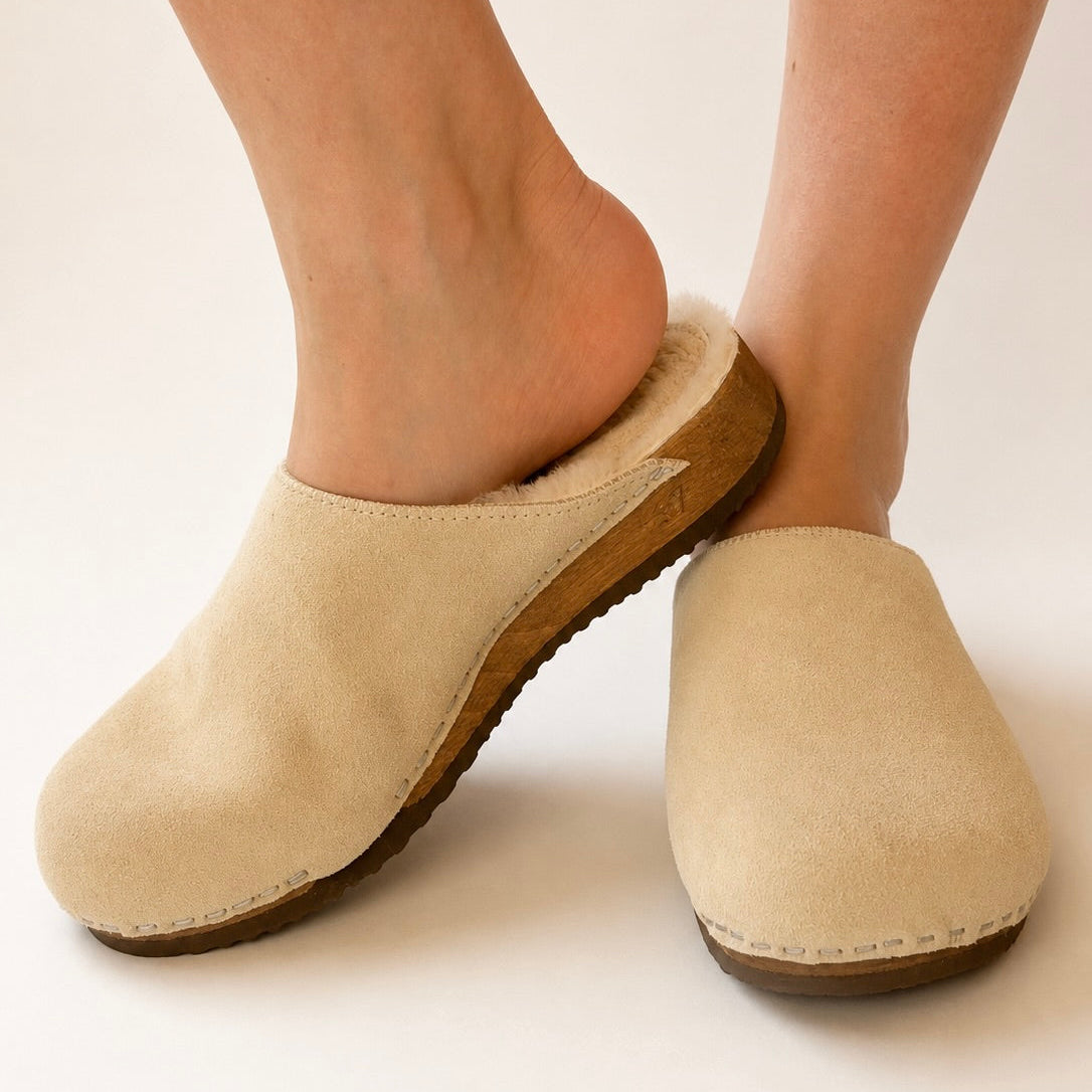 Pair of beige suede x pure lambswool clogs on a white background