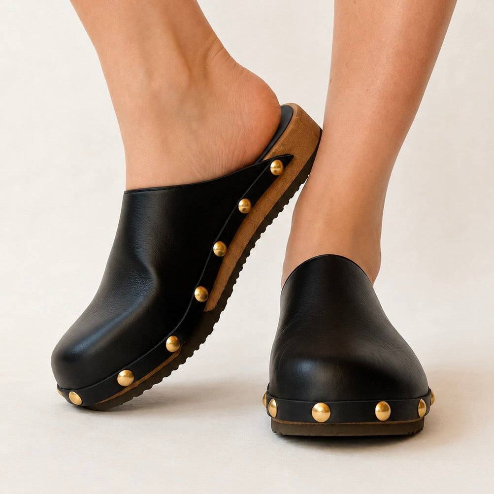 Black leather studded clog shoe on a white background