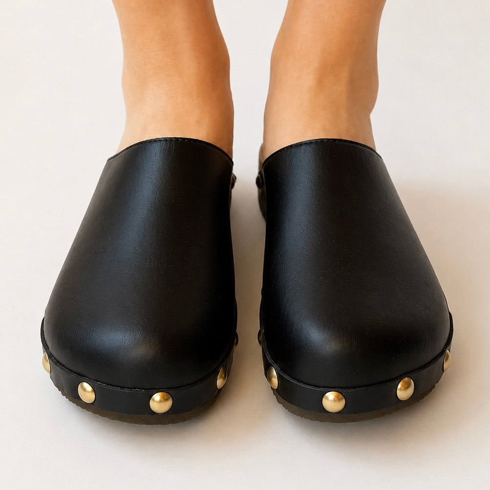 Pair of black clogs with tan insole on a white background