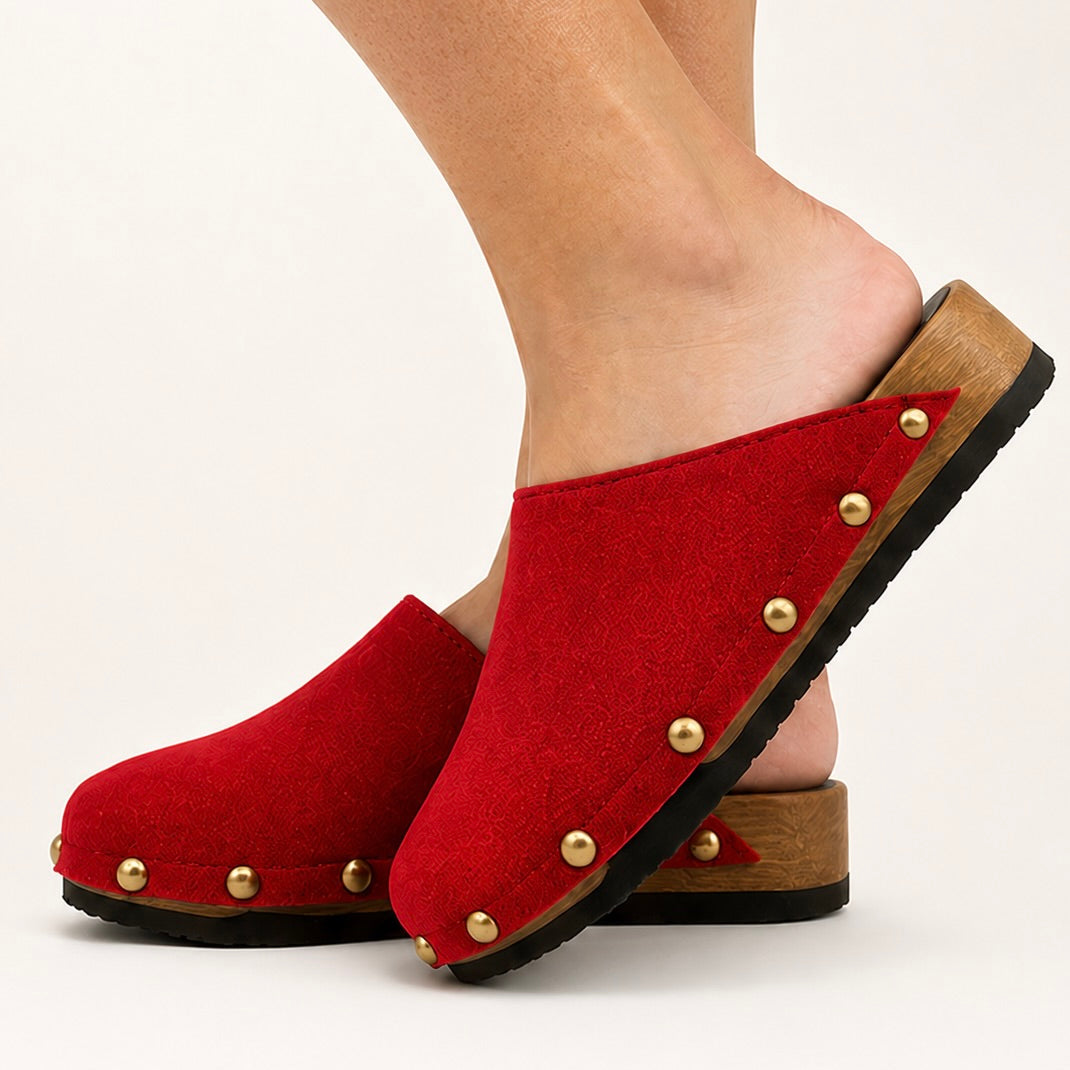 Pair of postkasse rød suede studs clogs on a white background