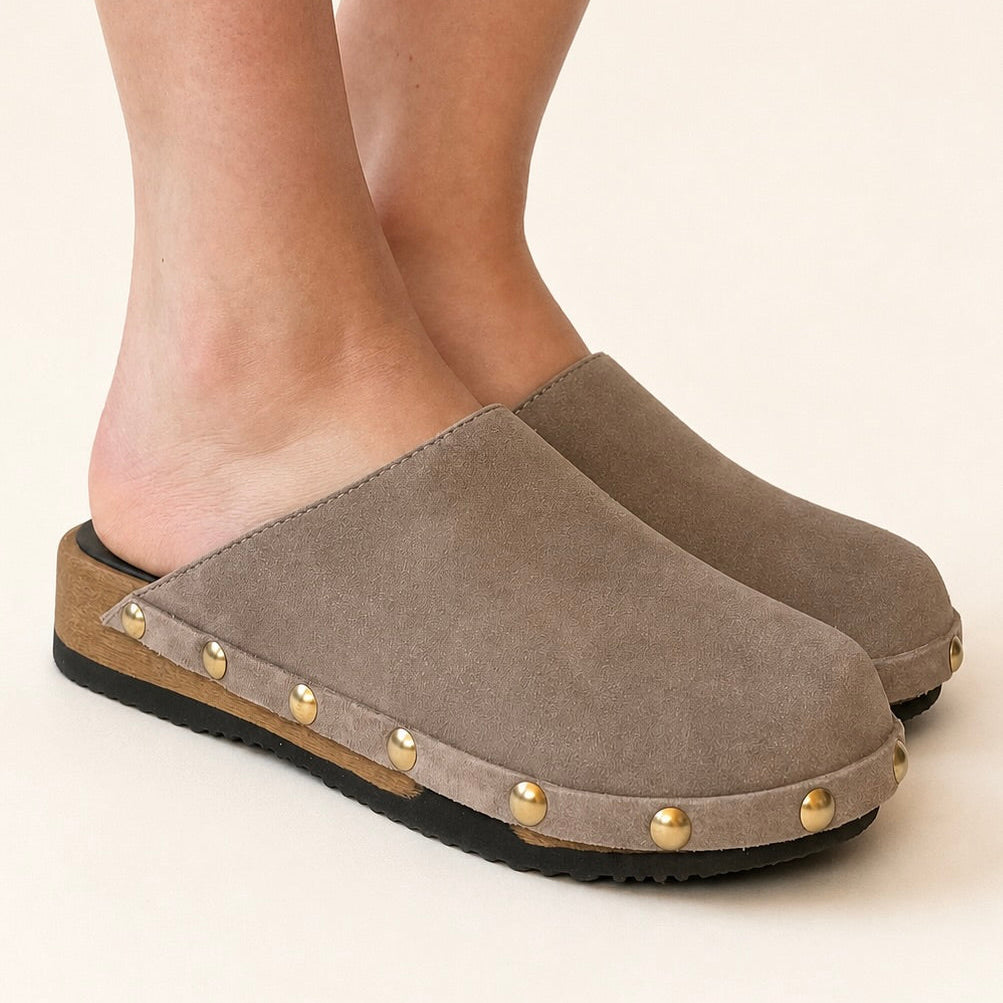 Taupe clogs with gold studs on a white background
