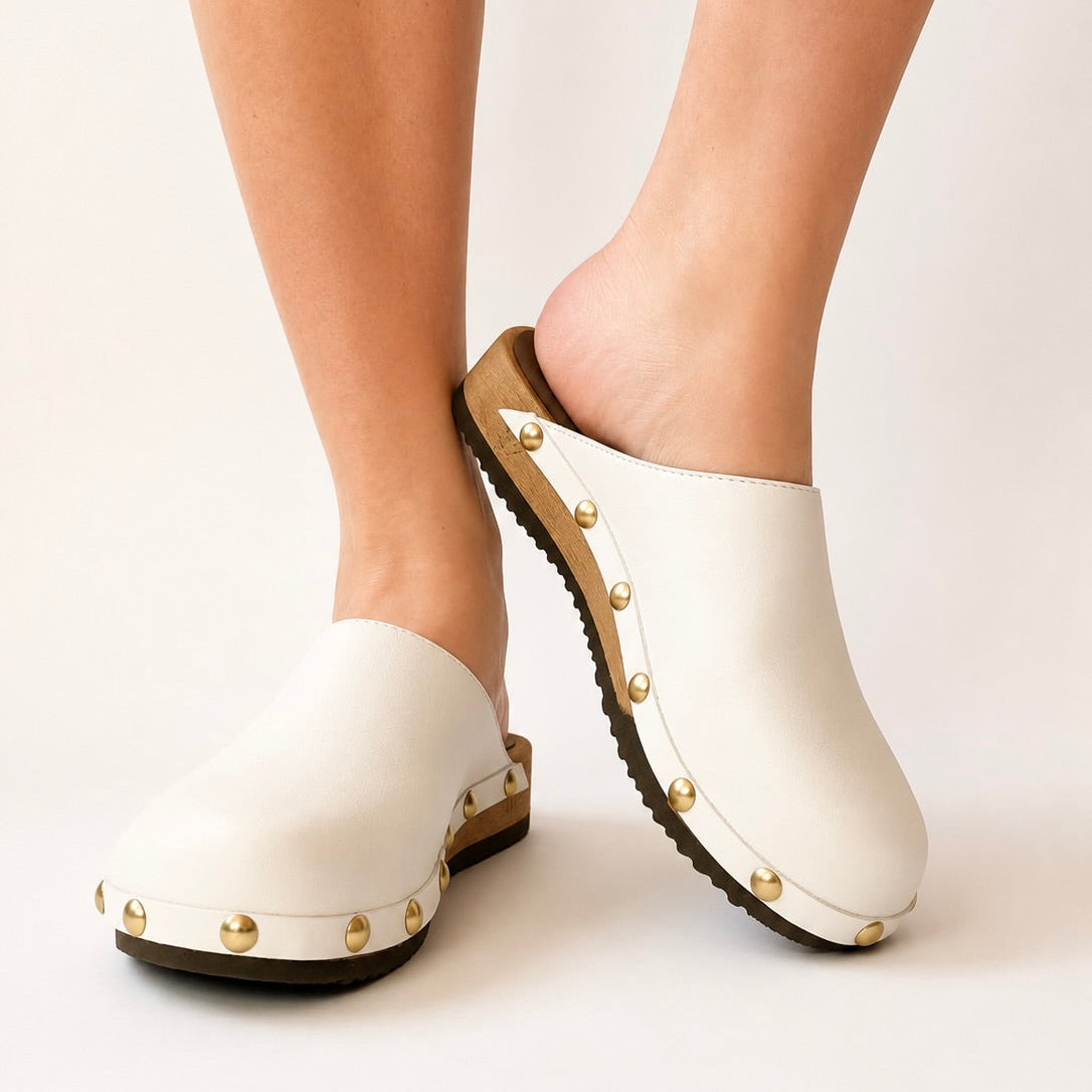 Pair of white leather studs clogs on a white background