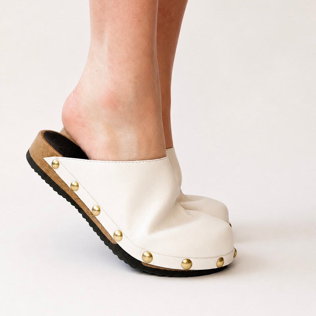 Pair of white leather studs clogs on a white background