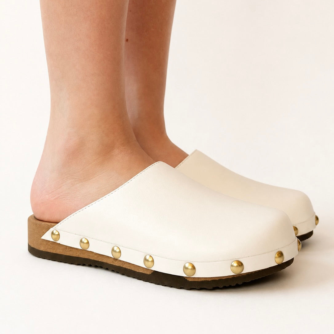 Pair of white leather studs clogs on a white background