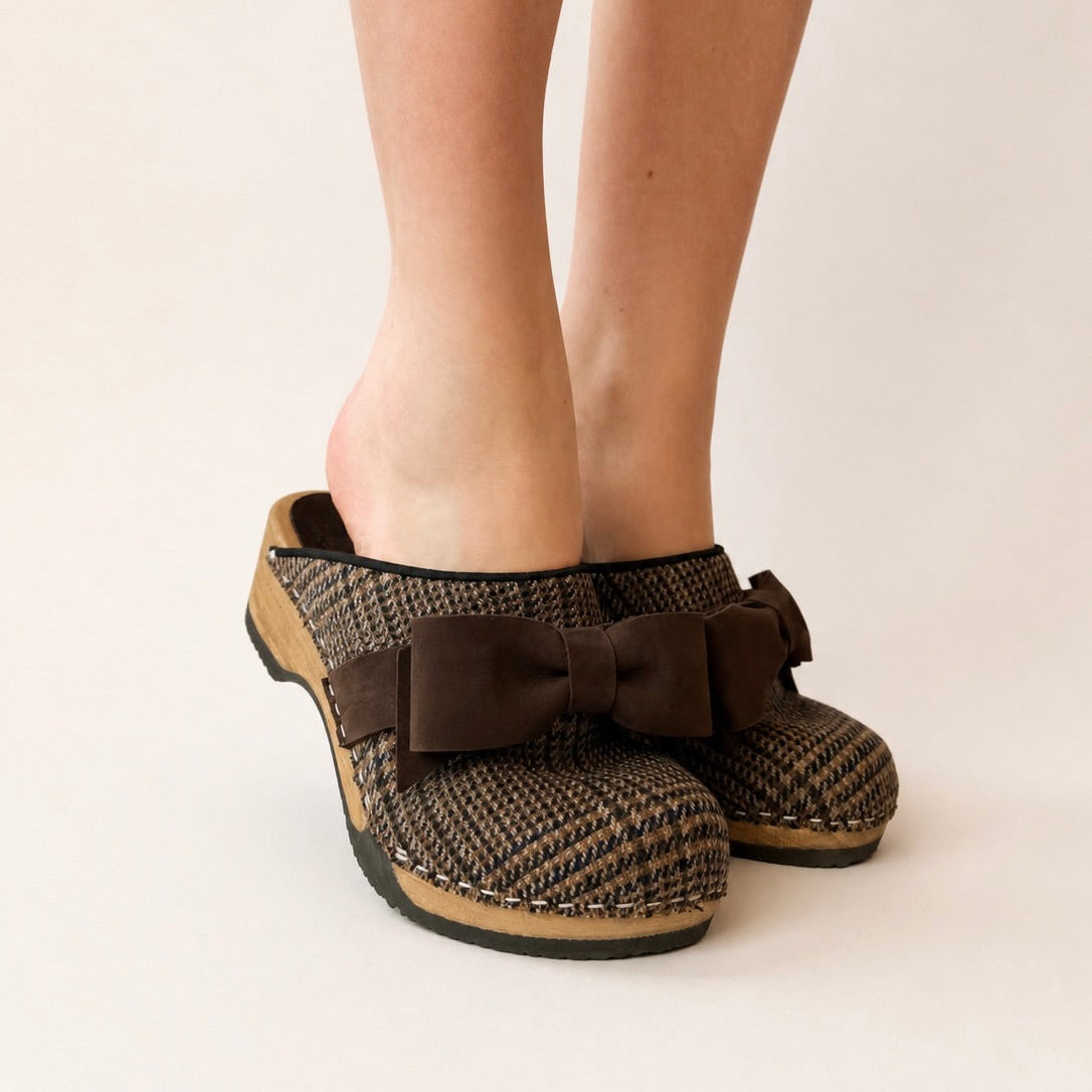 Brown woven clogs with wooden sole on a white background