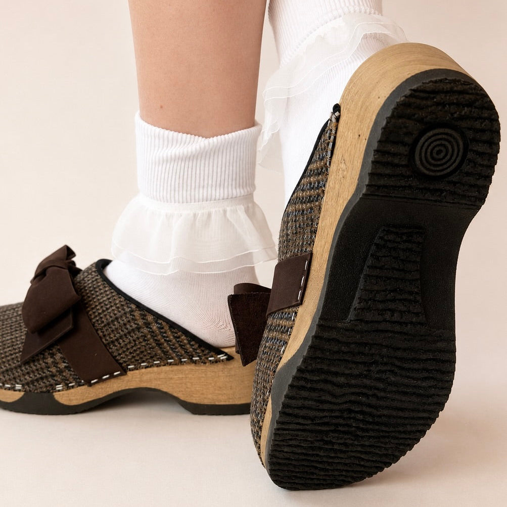 Brown woven clog shoe with a strap on a white background