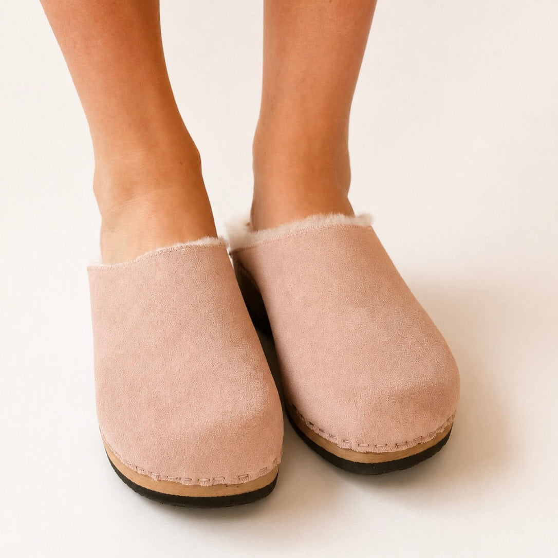 Pink clog shoe with wooden sole on a white background