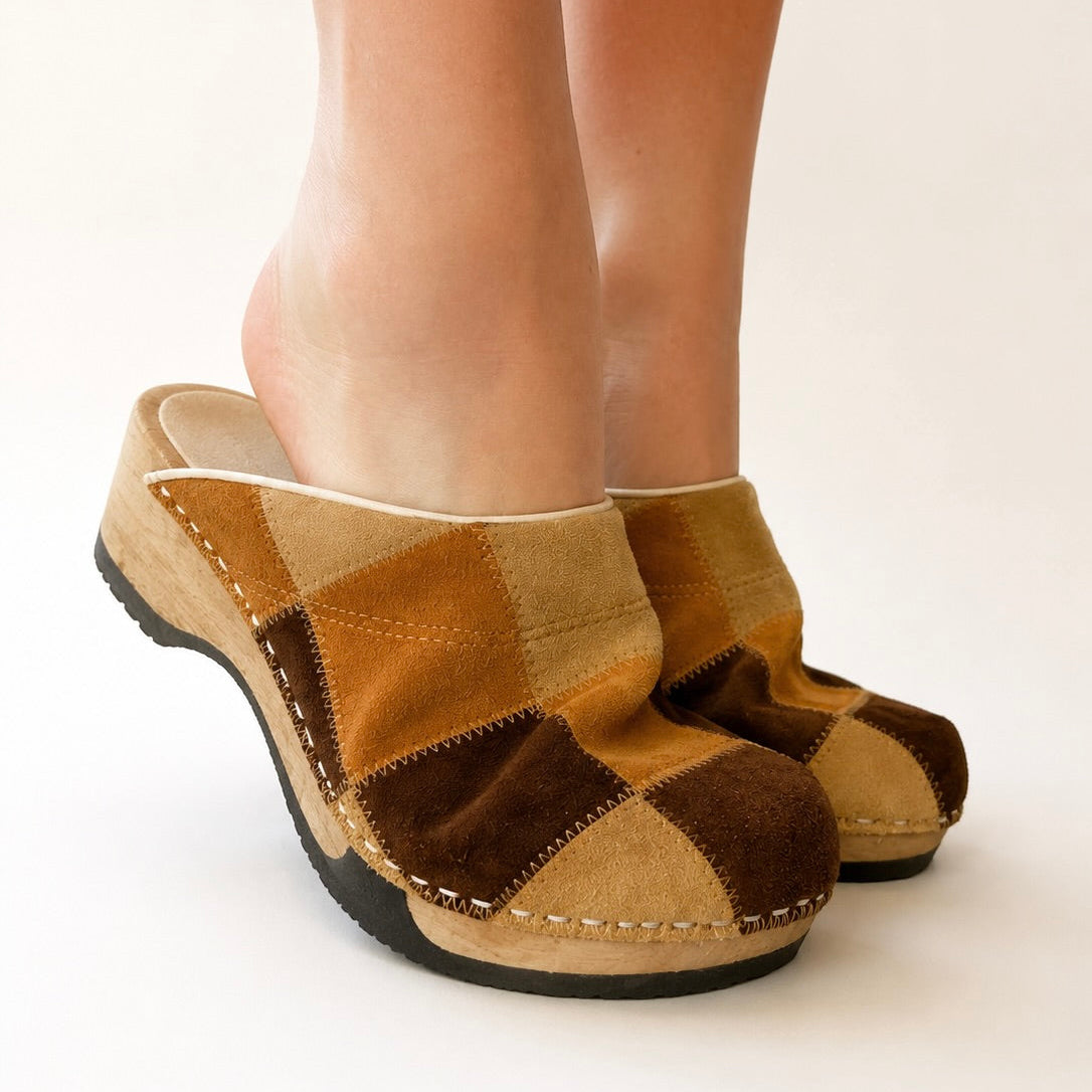 Pair of brown and beige checkered clogs on a white background