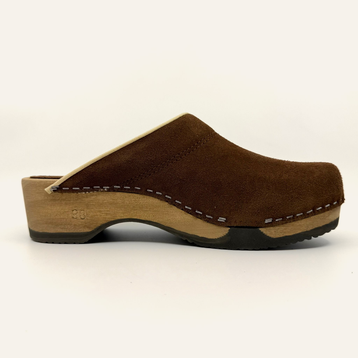 A brown suede clogs with a light wood wedge heel and a black outsole, shown from a side profile view against a plain white background.