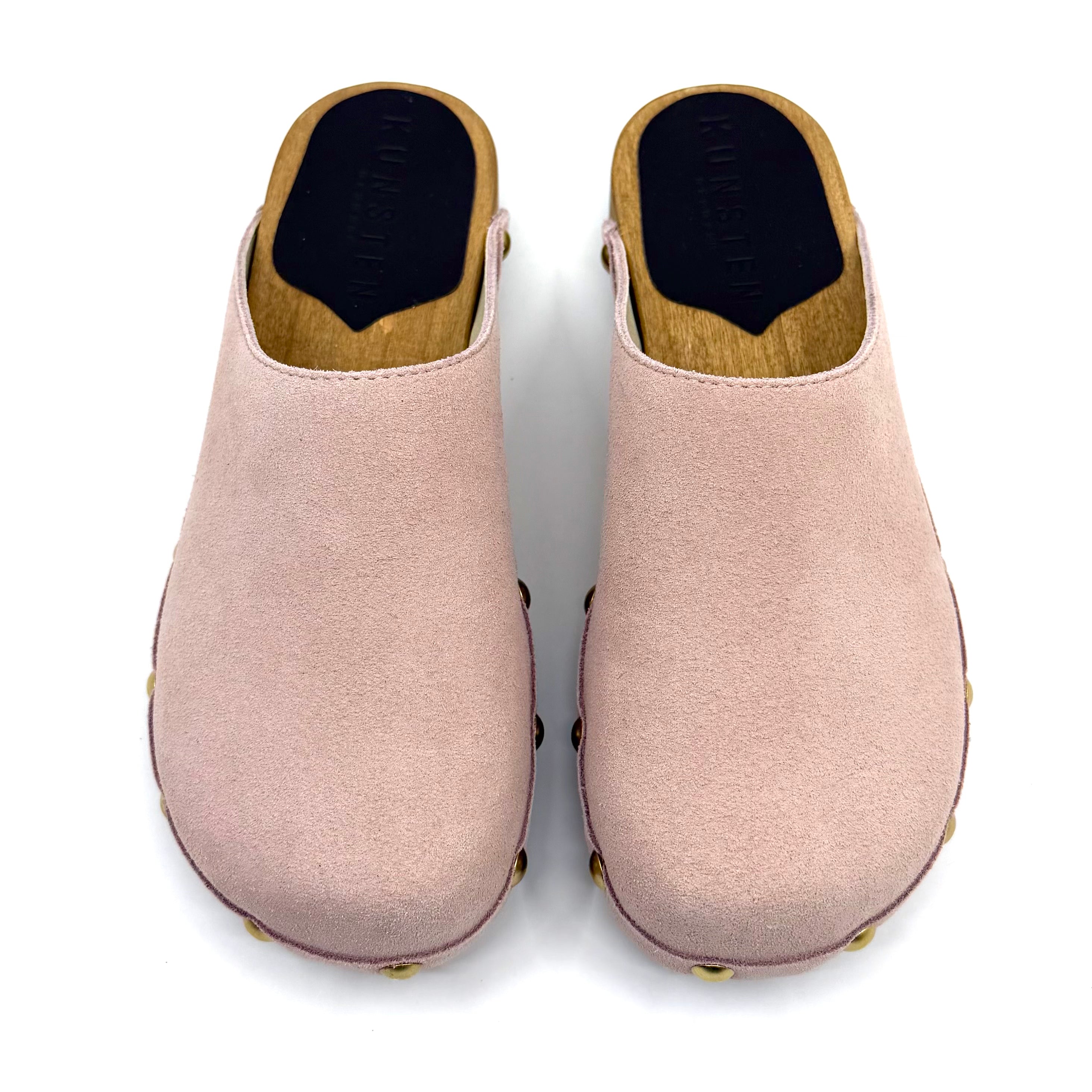 Pair of pink clogs with wooden soles on a white background