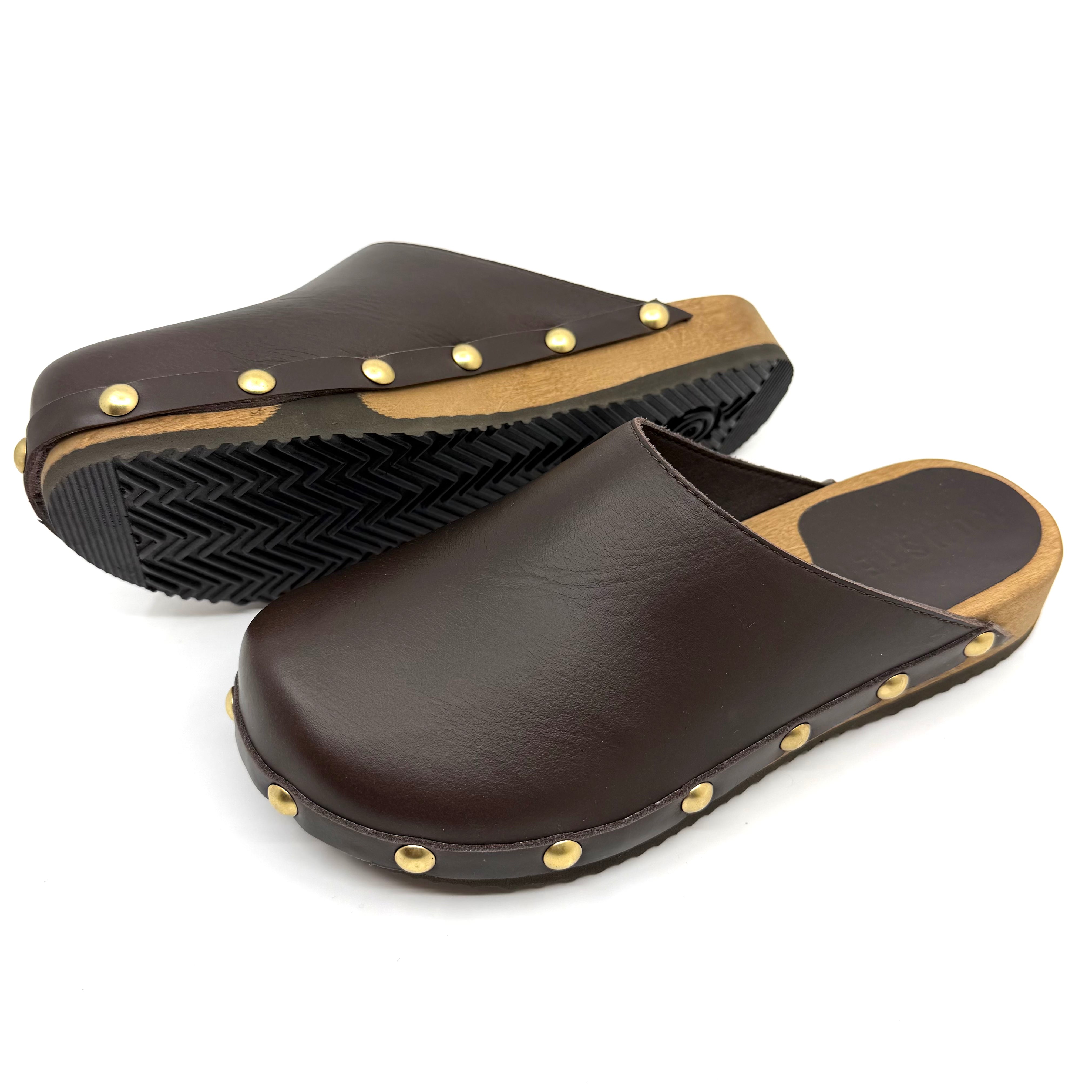 Brown leather clogs with gold studs on a white background